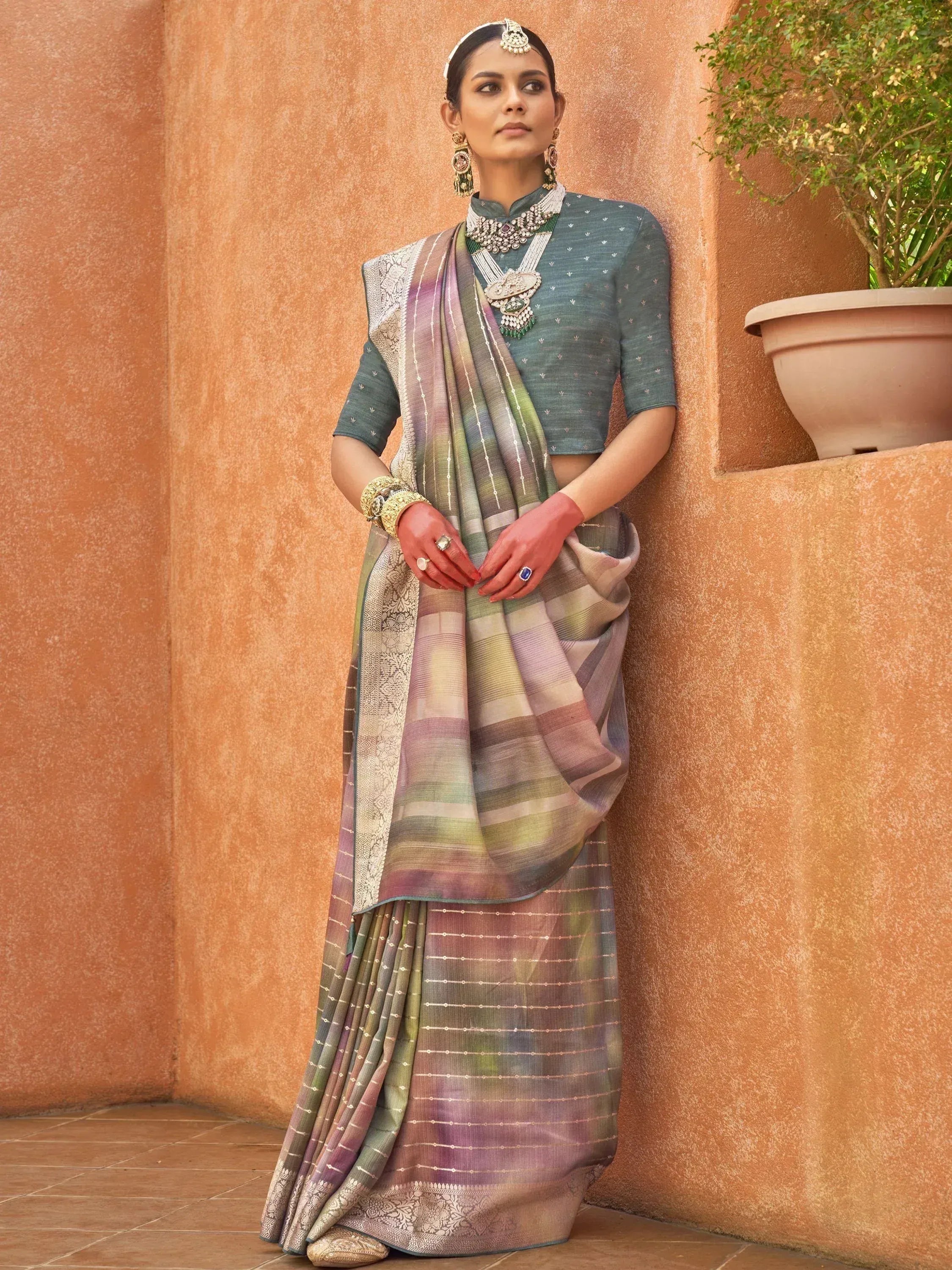 Woman in designer saree with embroidered blouse, traditional jewelry, and colorful ombre pallu, perfect for ethnic occasions.