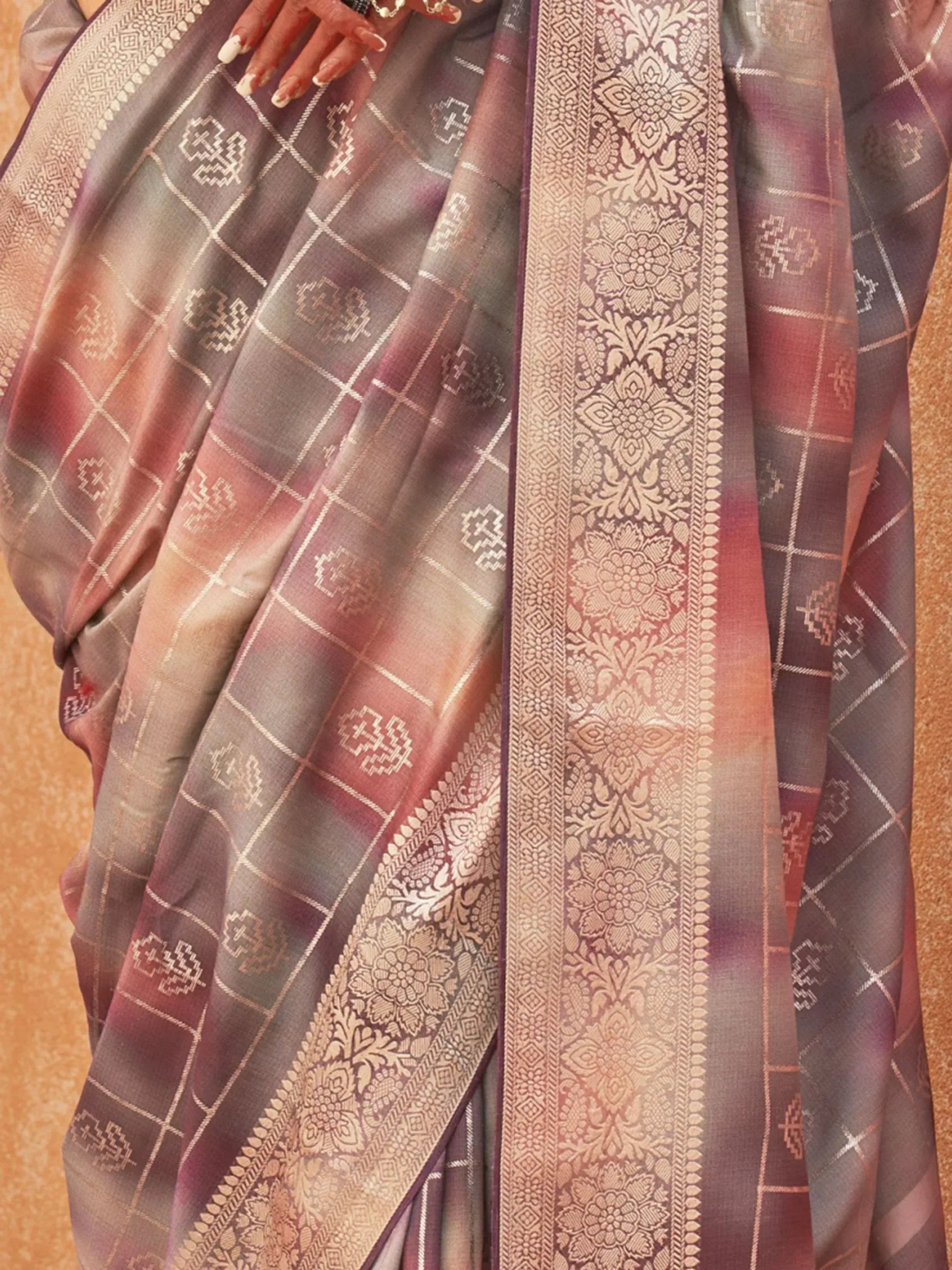 Elegant purple and gold ethnic saree with intricate floral border and geometric patterns, perfect for festive occasions.