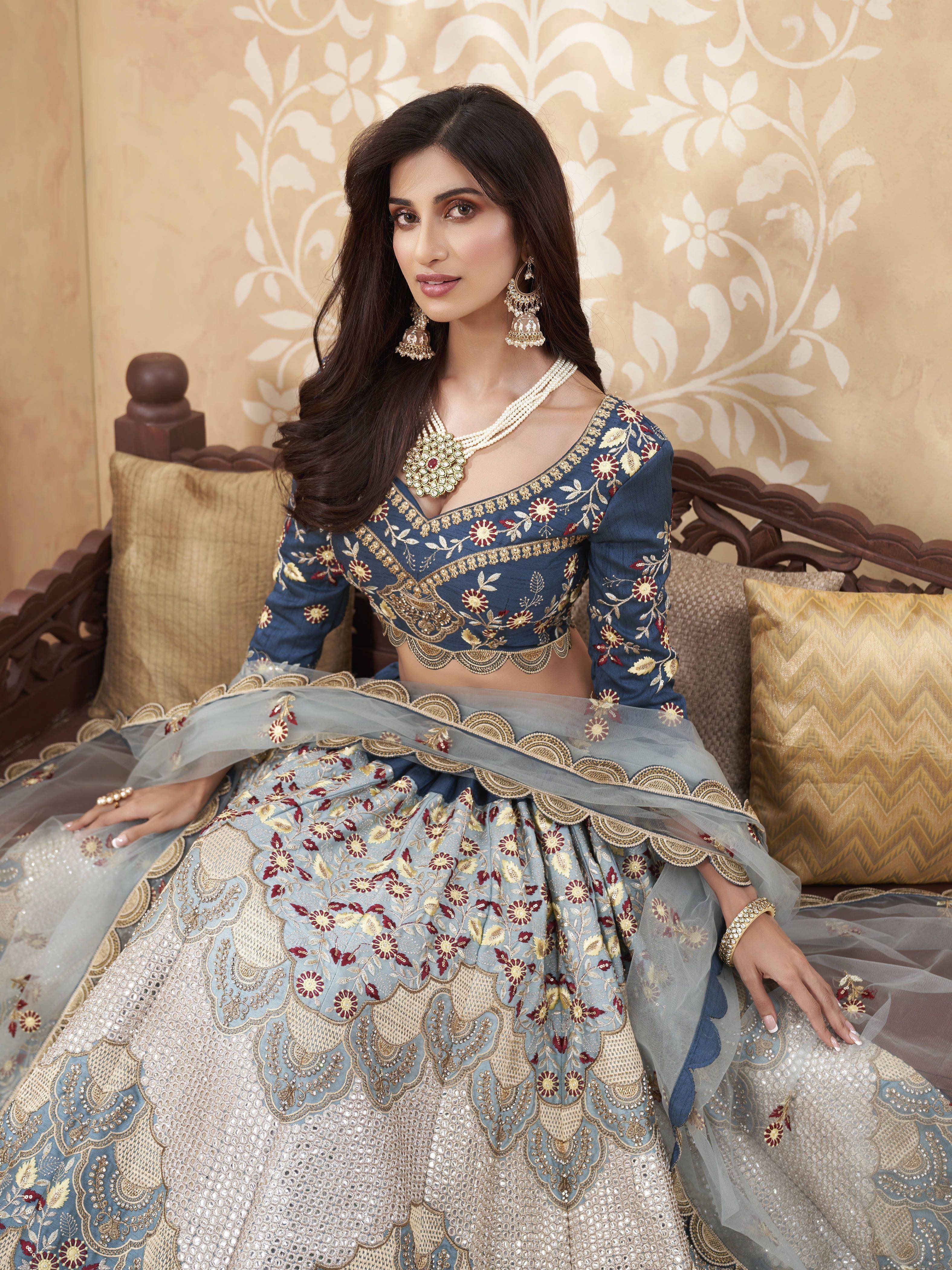 Blue embroidered lehenga choli with gold and maroon floral work, perfect for Indian weddings and festive occasions.