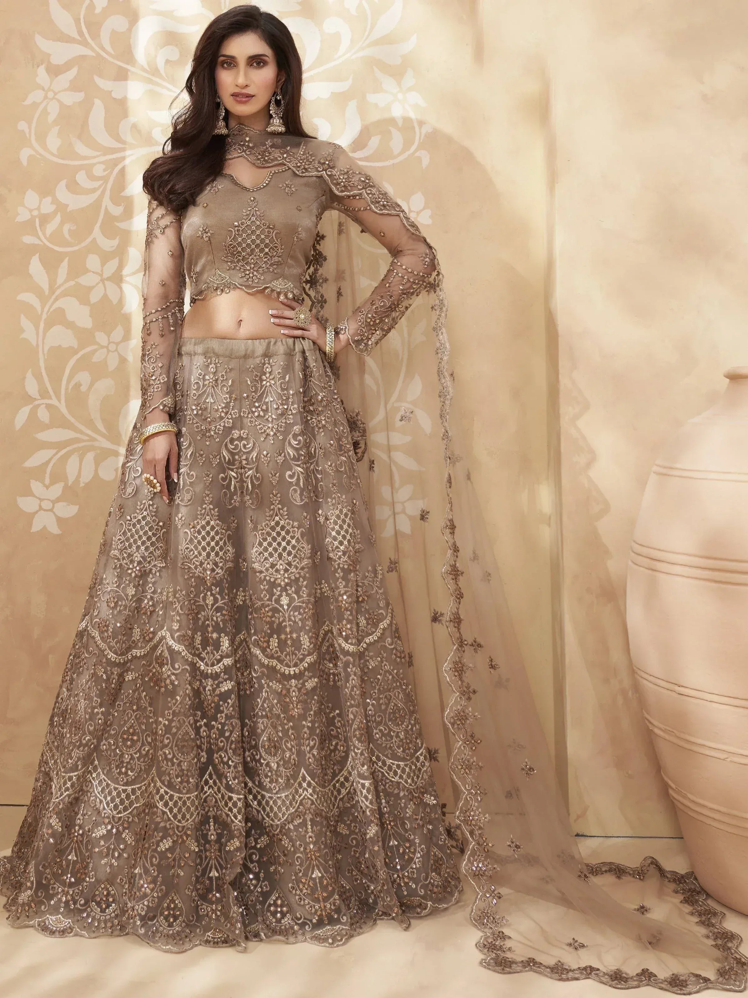 Elegant beige embroidered lehenga choli with sheer sleeves and dupatta, perfect for Indian weddings and festive occasions.