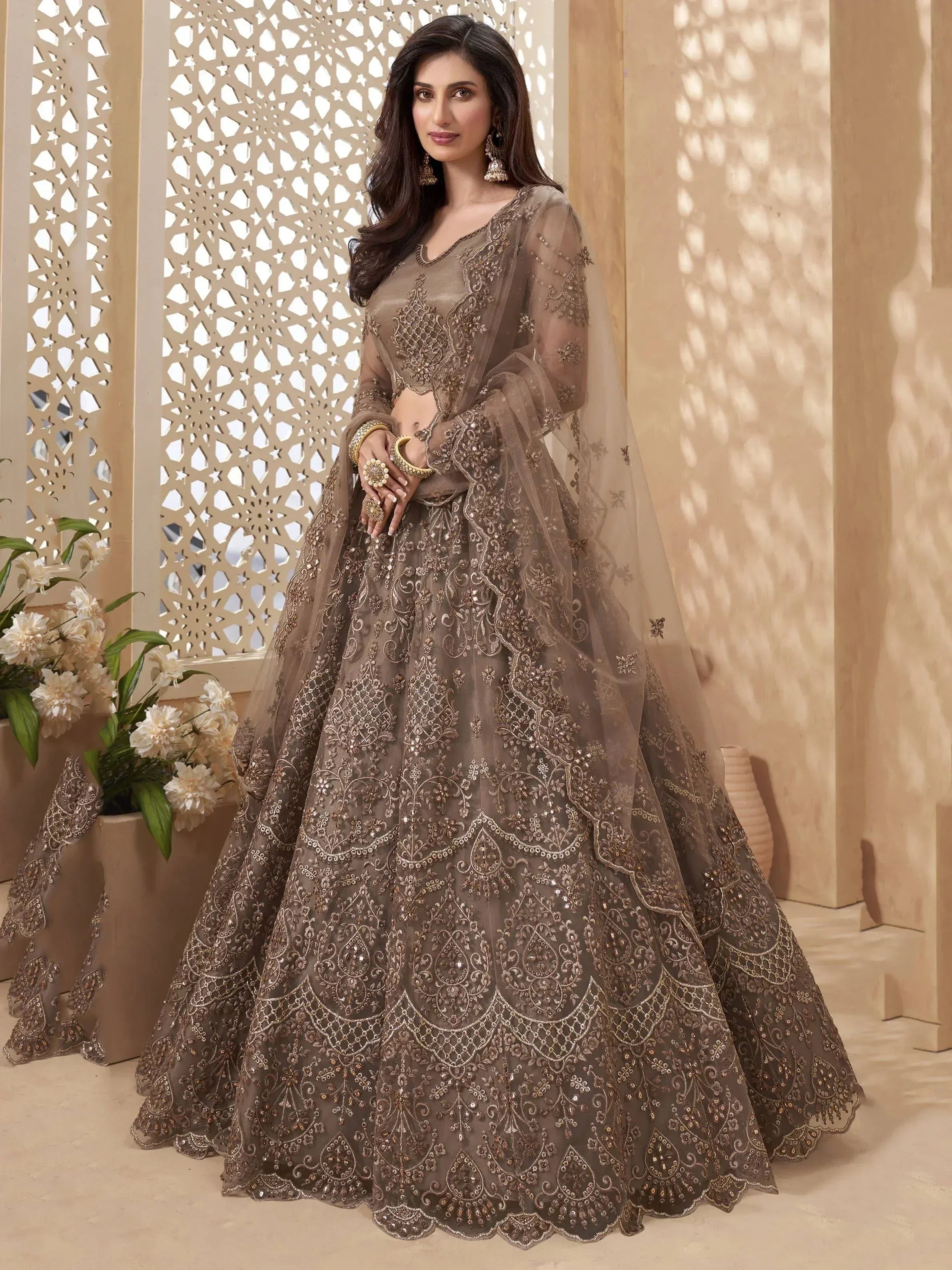 Elegant brown embroidered lehenga choli with sheer dupatta, perfect for Indian weddings and festive occasions.