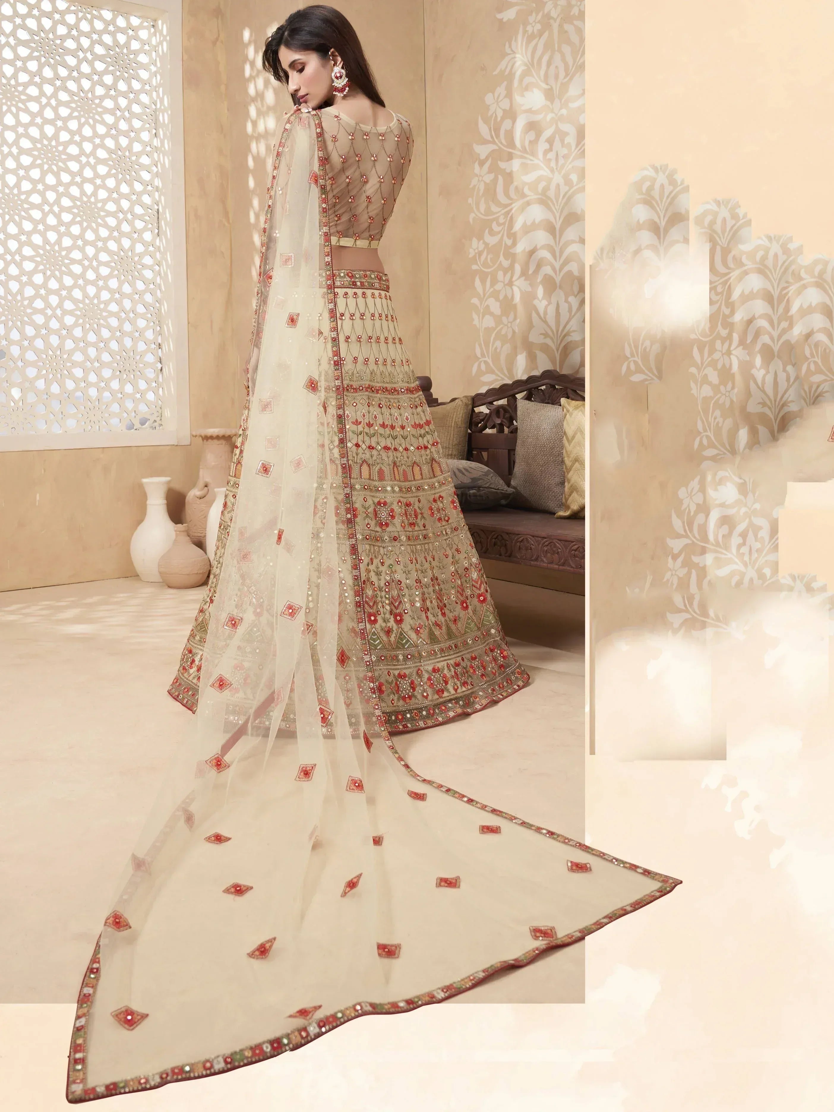 Elegant beige lehenga choli with red floral embroidery and sheer dupatta, perfect for Indian weddings and festive occasions.