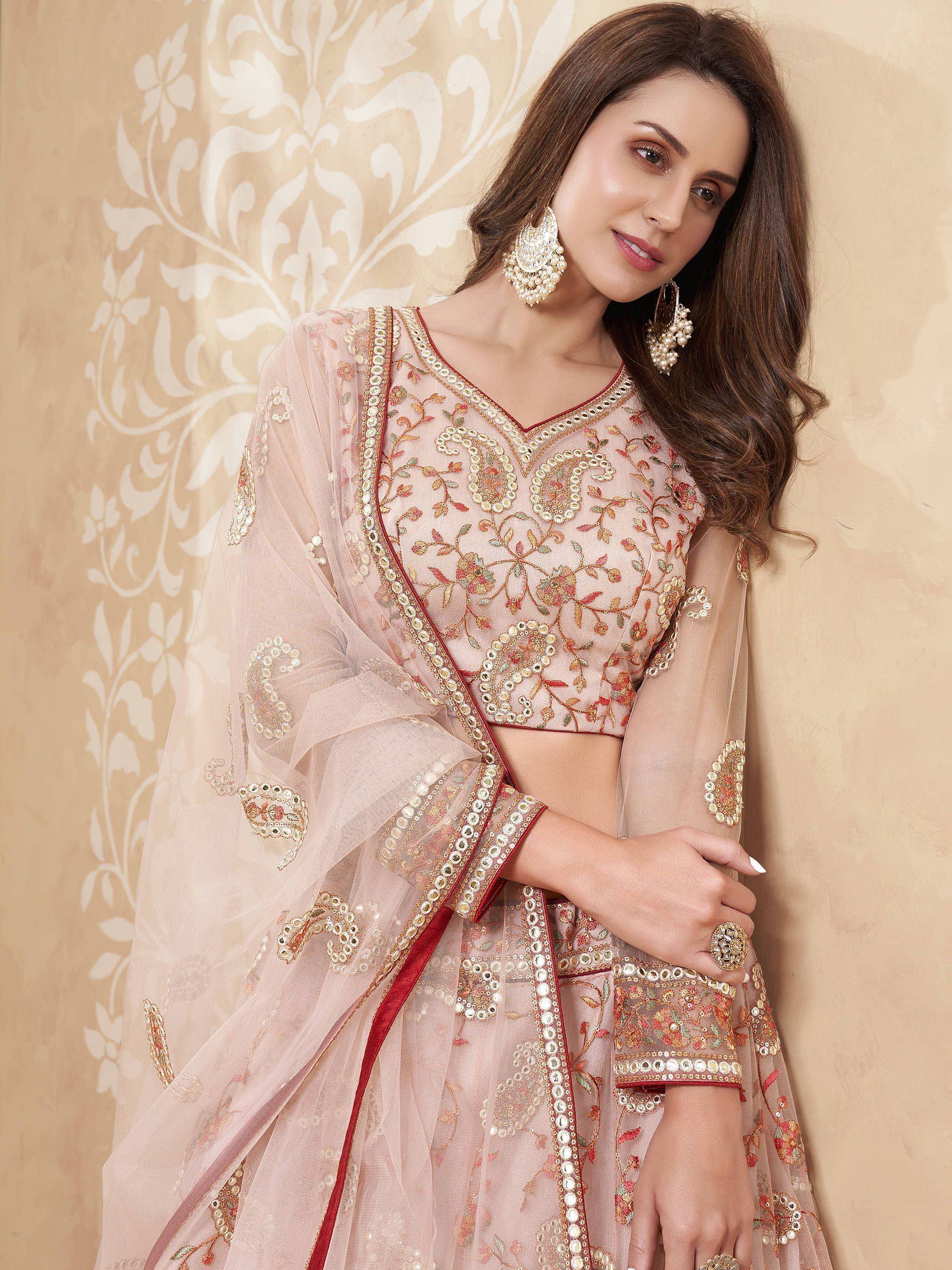 Elegant peach embroidered lehenga choli with mirror work and sheer dupatta, perfect for Indian weddings and festive occasions.