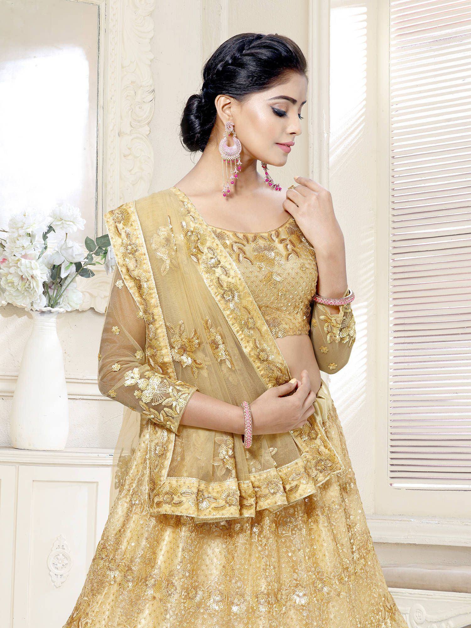 Golden embroidered lehenga choli with sheer dupatta, perfect for Indian weddings and festive occasions.