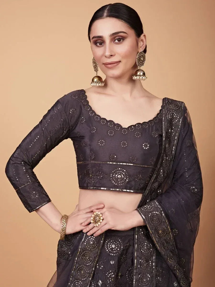 Black embroidered lehenga choli with scalloped neckline and gold jhumka earrings