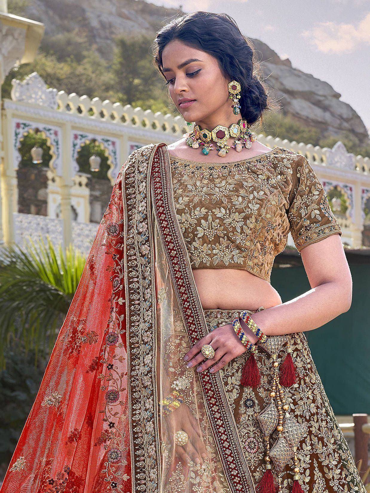 Elegant Indian bridal lehenga choli with gold embroidery, red dupatta, and traditional jewelry