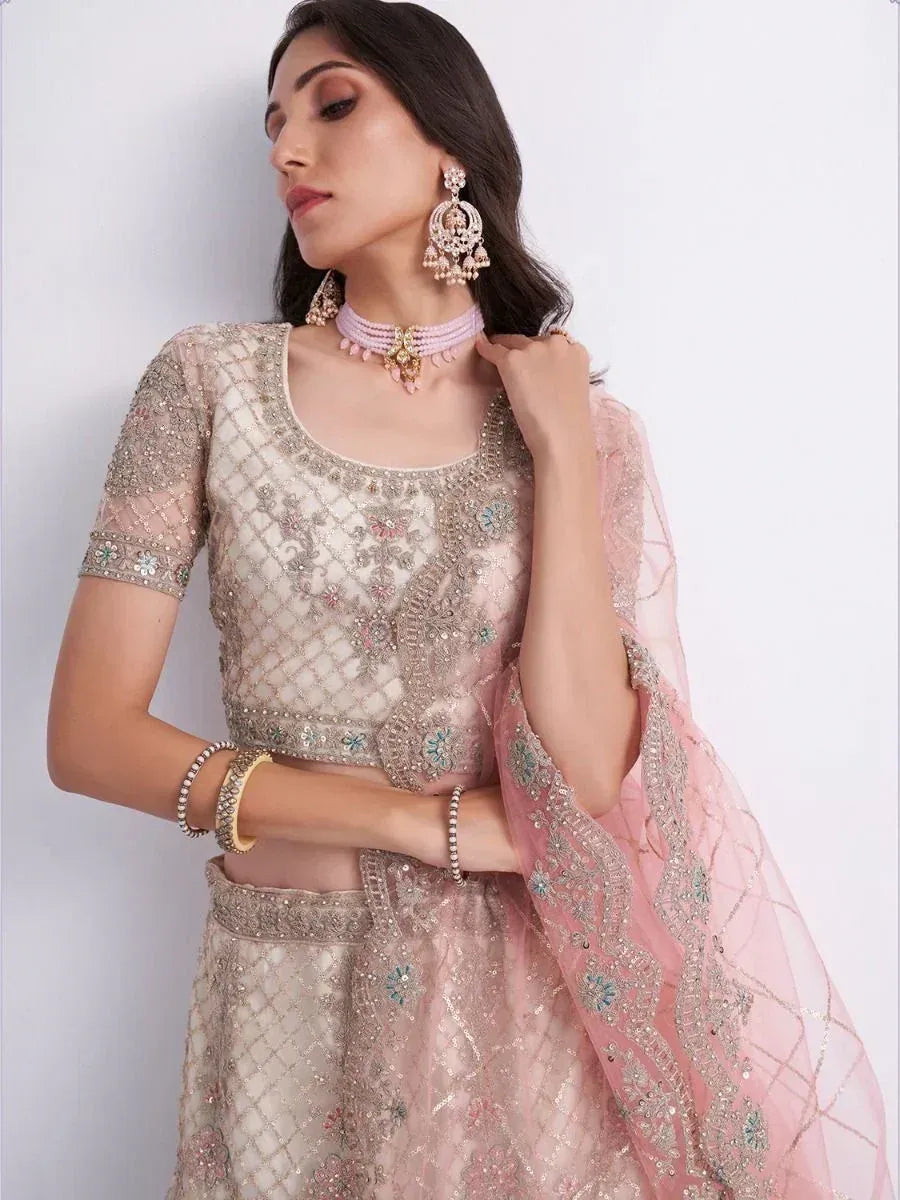 Elegant pink and beige embroidered lehenga choli with matching dupatta and traditional jewelry