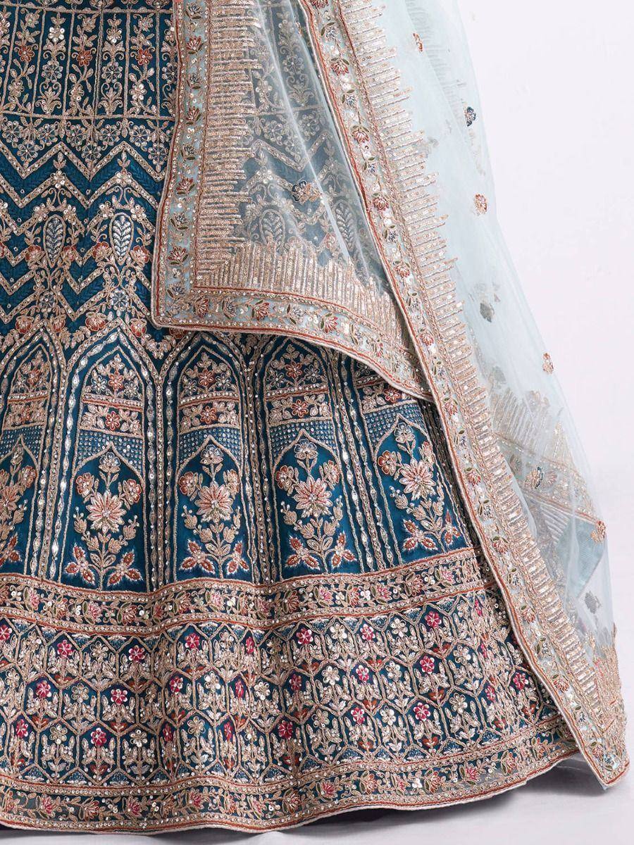 Blue designer lehenga with intricate gold and floral embroidery, paired with sheer dupatta for ethnic wear.
