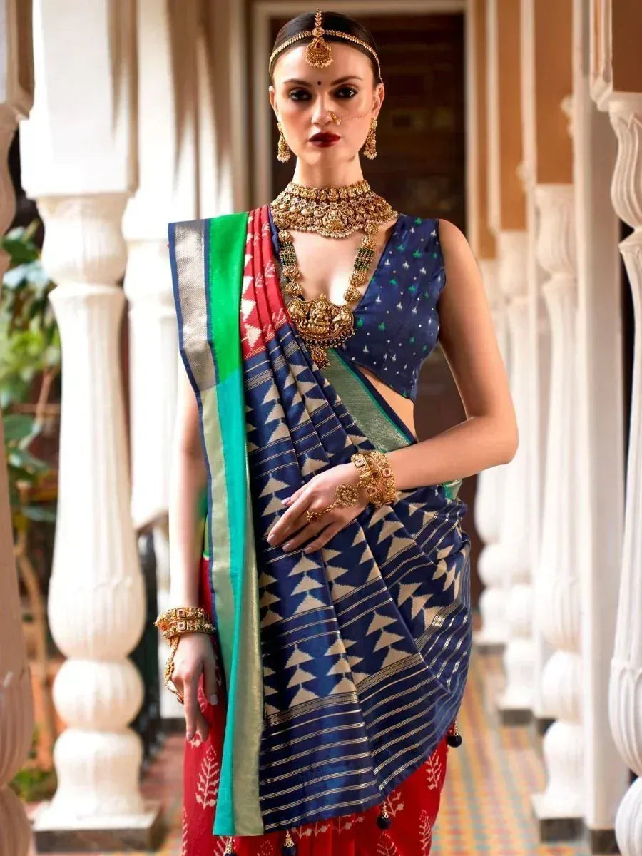 Elegant woman in blue and red ethnic saree with gold jewelry, showcasing traditional Indian fashion.