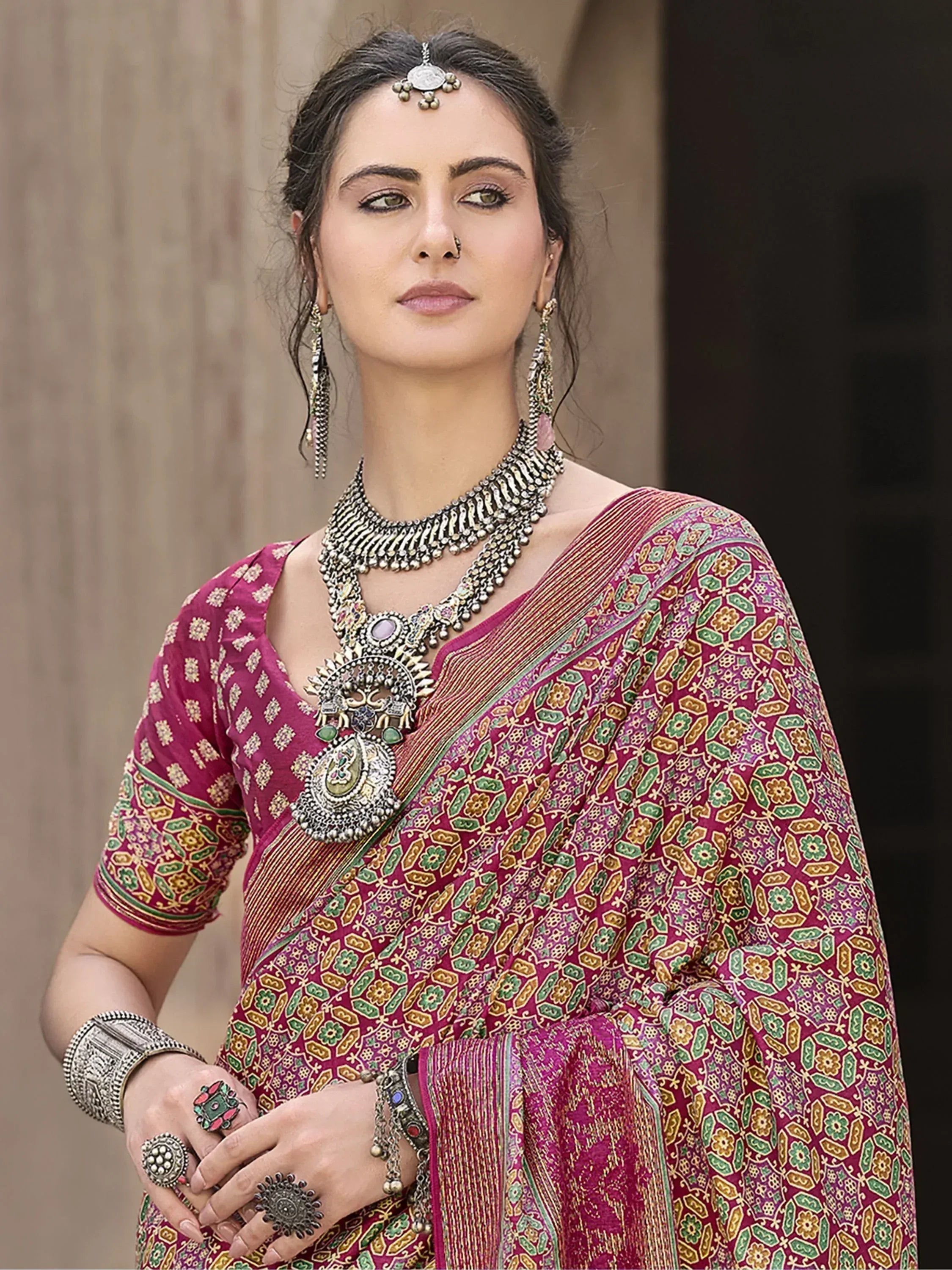 Woman in maroon floral saree with traditional jewelry, ethnic Indian wear