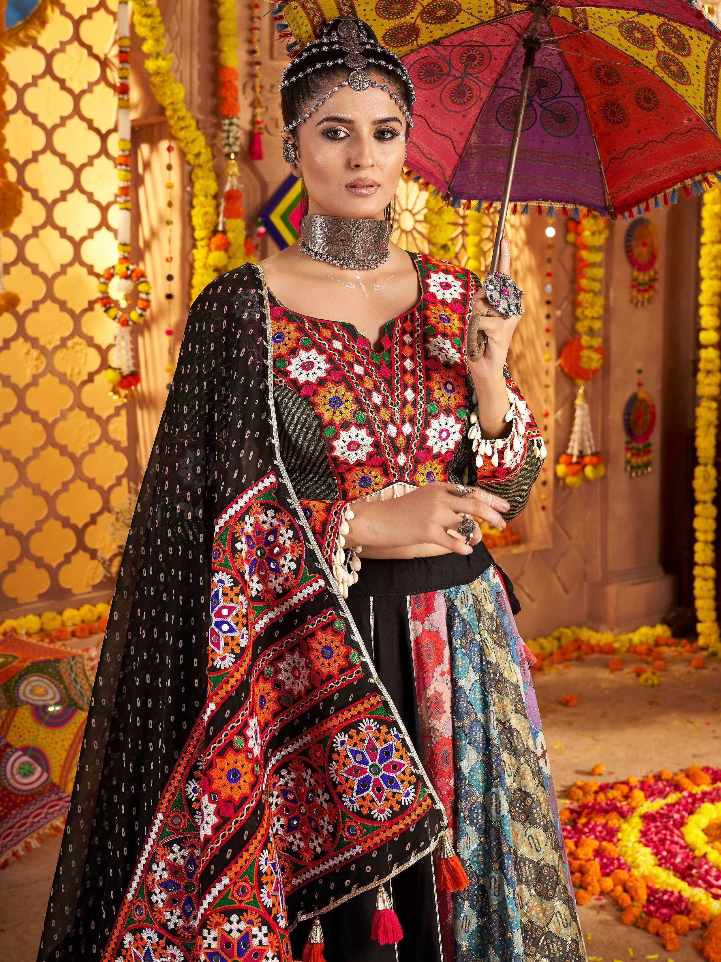 Woman in vibrant Indian ethnic wear with mirror work, holding colorful umbrella, festive floral backdrop