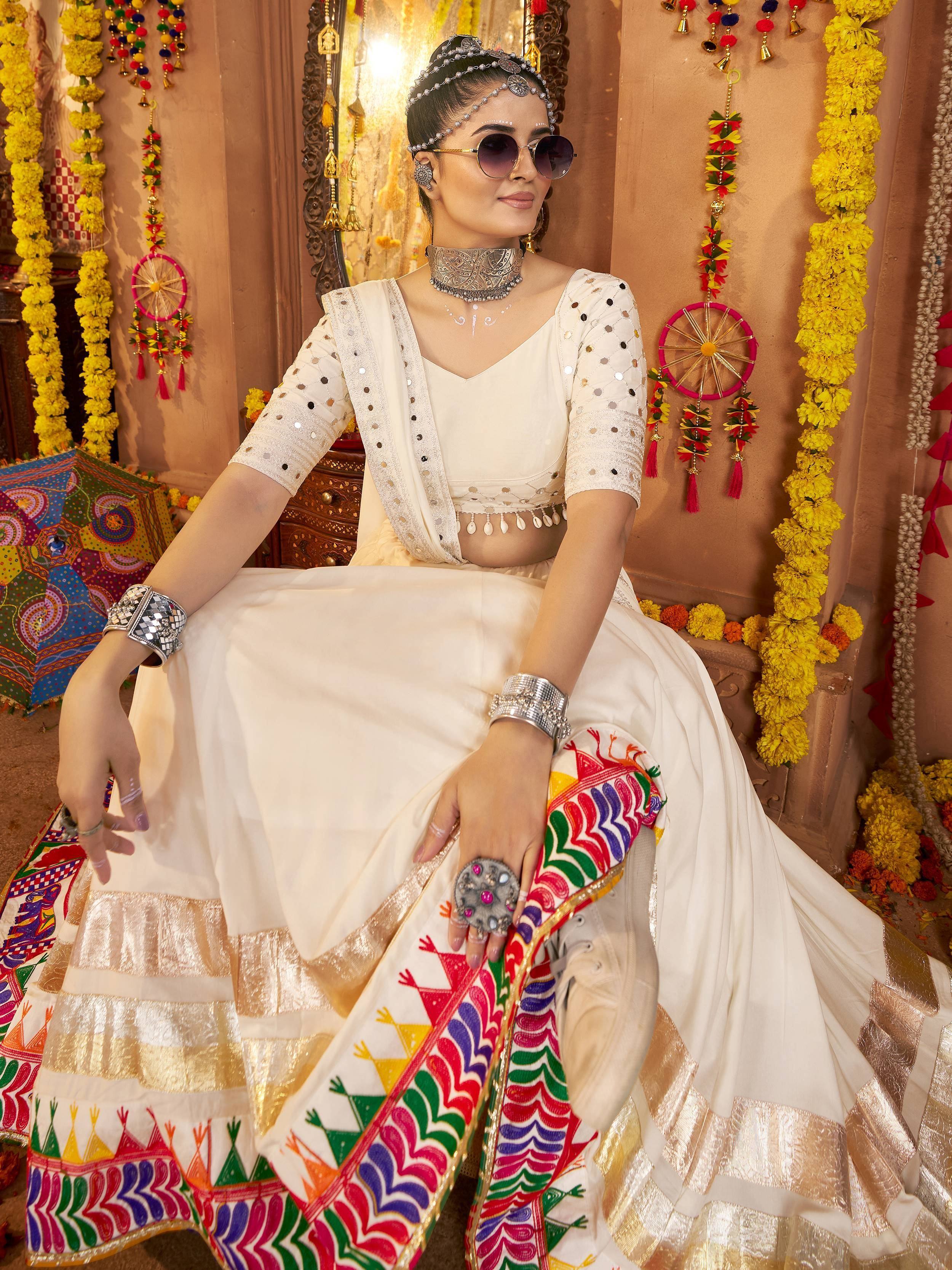 White embroidered lehenga choli with colorful mirror work, traditional Indian ethnic wear for festive occasions