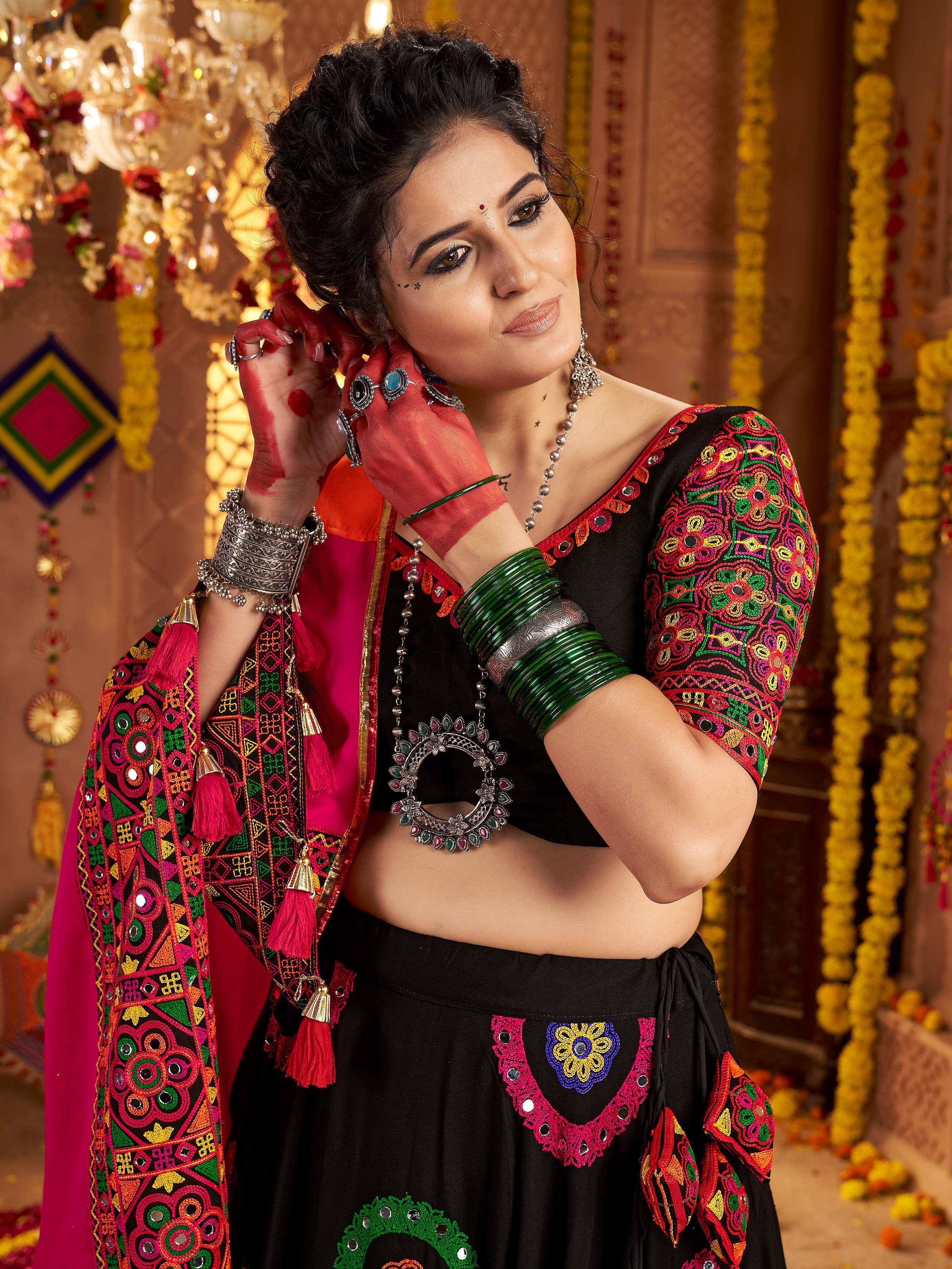 Woman in vibrant Indian ethnic wear with mirror work, colorful embroidery, and traditional jewelry for festive occasions