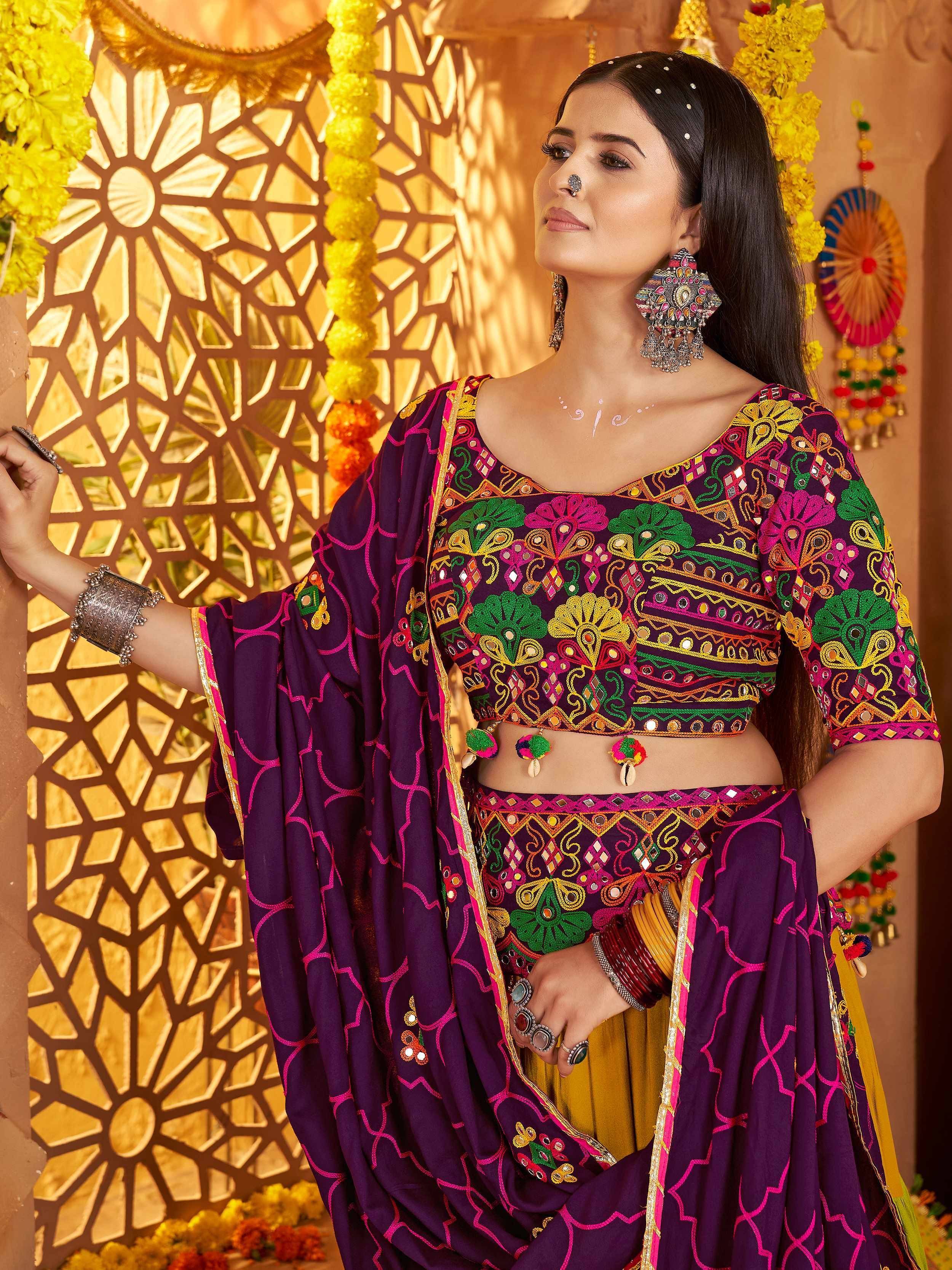 Woman in vibrant purple embroidered lehenga choli with mirror work, traditional Indian ethnic wear