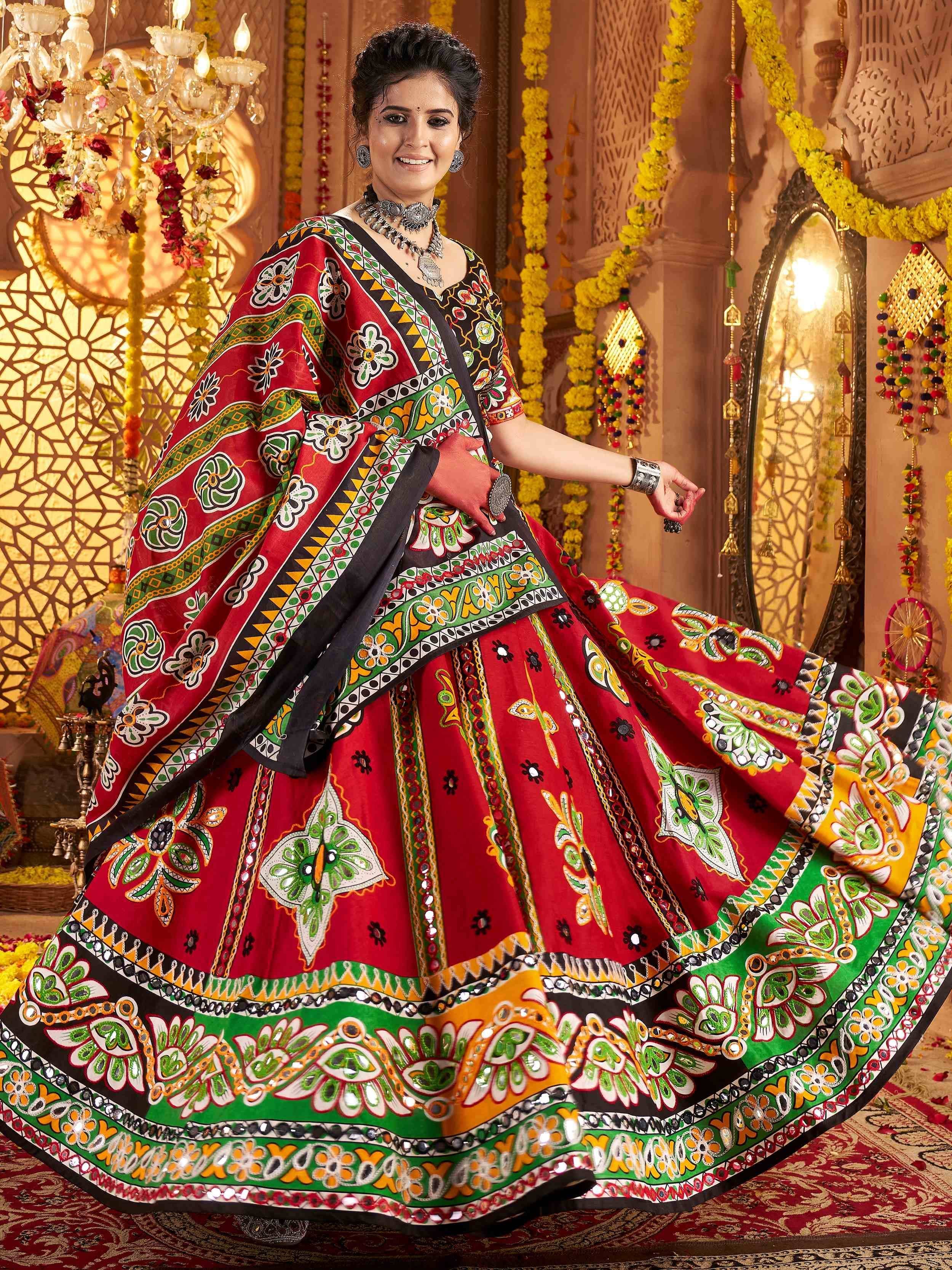 Vibrant red and green printed ethnic lehenga choli with mirror work, perfect for festive occasions