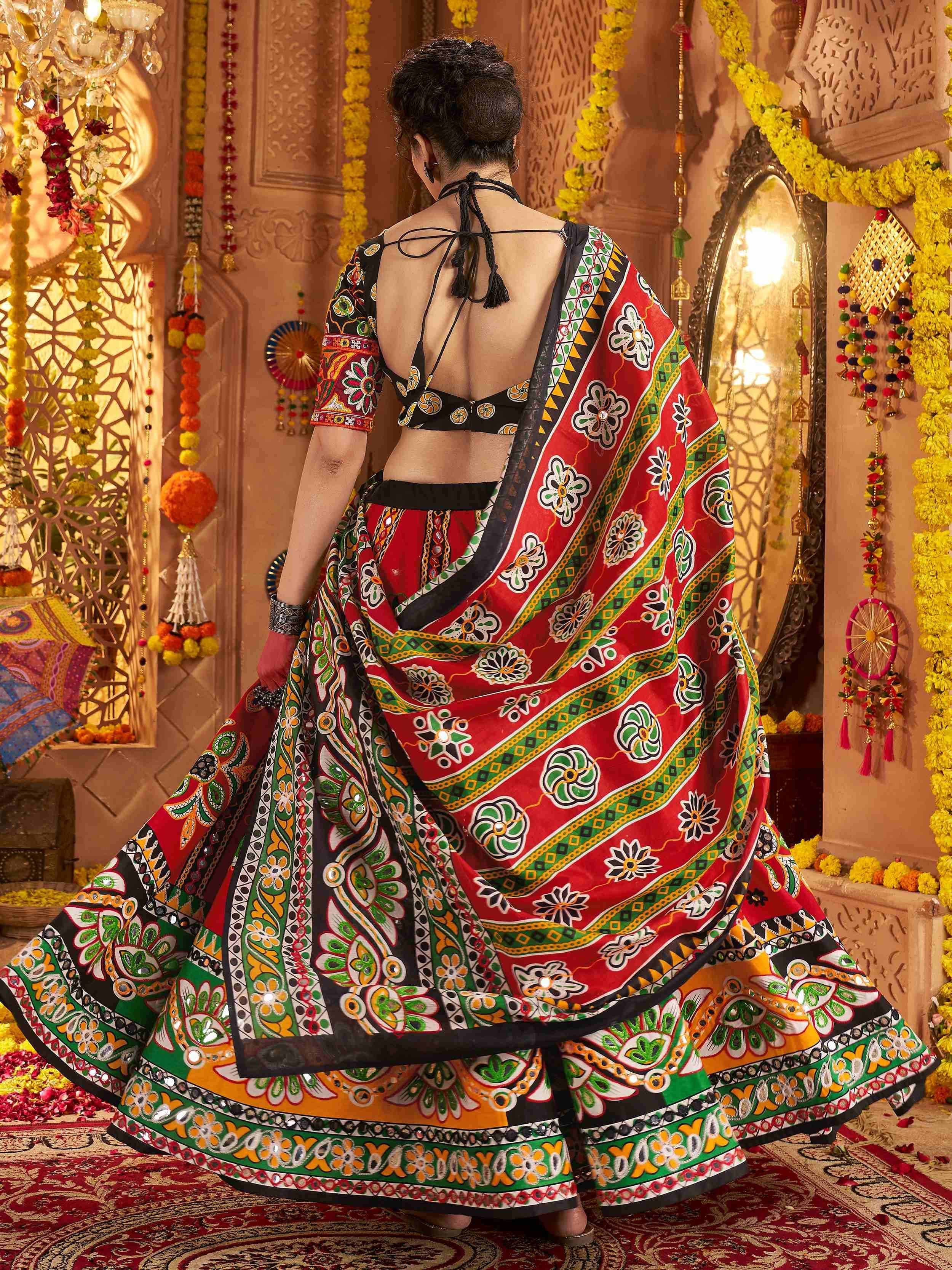 Vibrant red and green printed lehenga choli with mirror work, back view in festive Indian decor