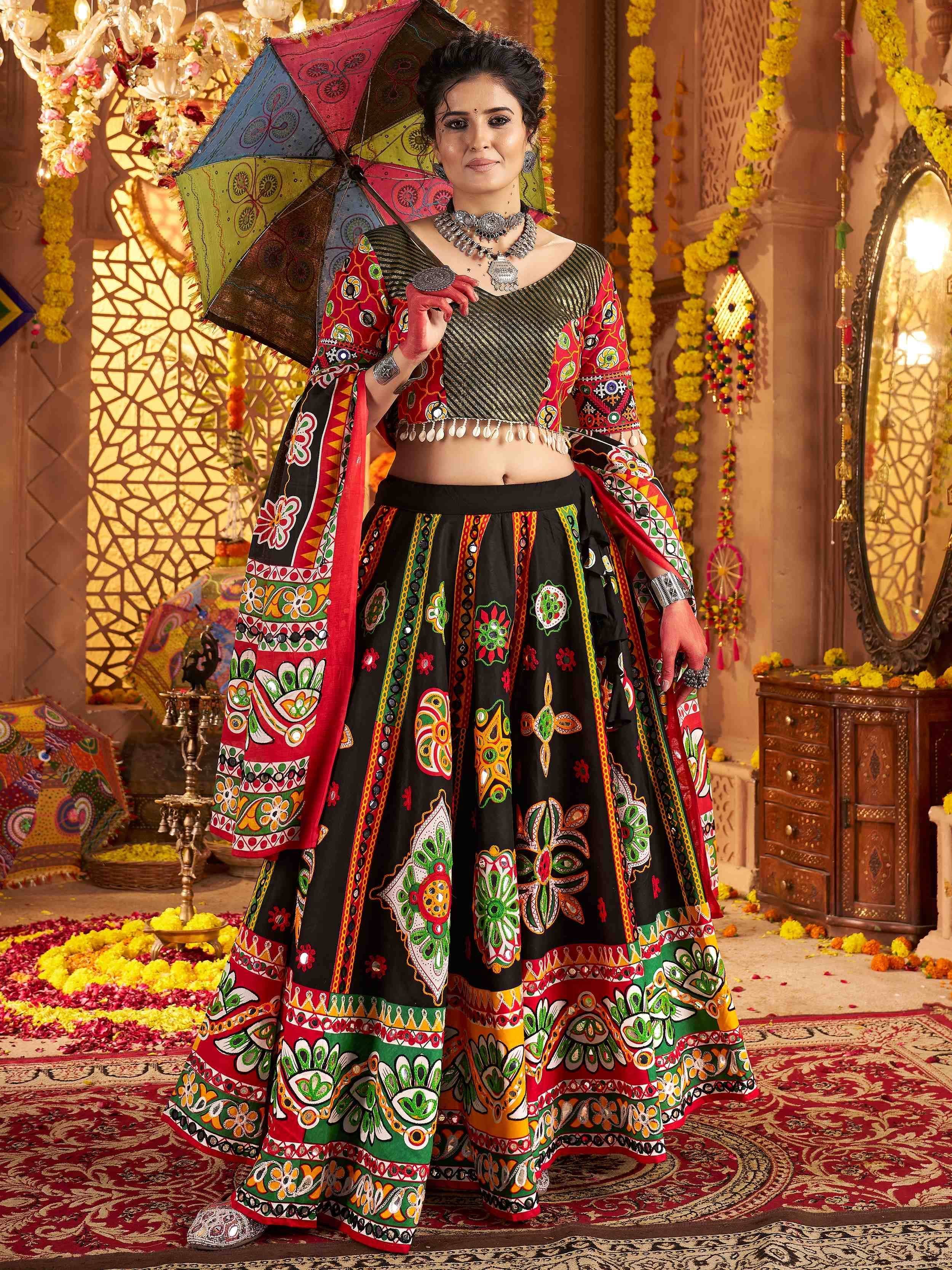 Woman in vibrant Indian ethnic wear with mirror work, holding colorful umbrella, festive decor