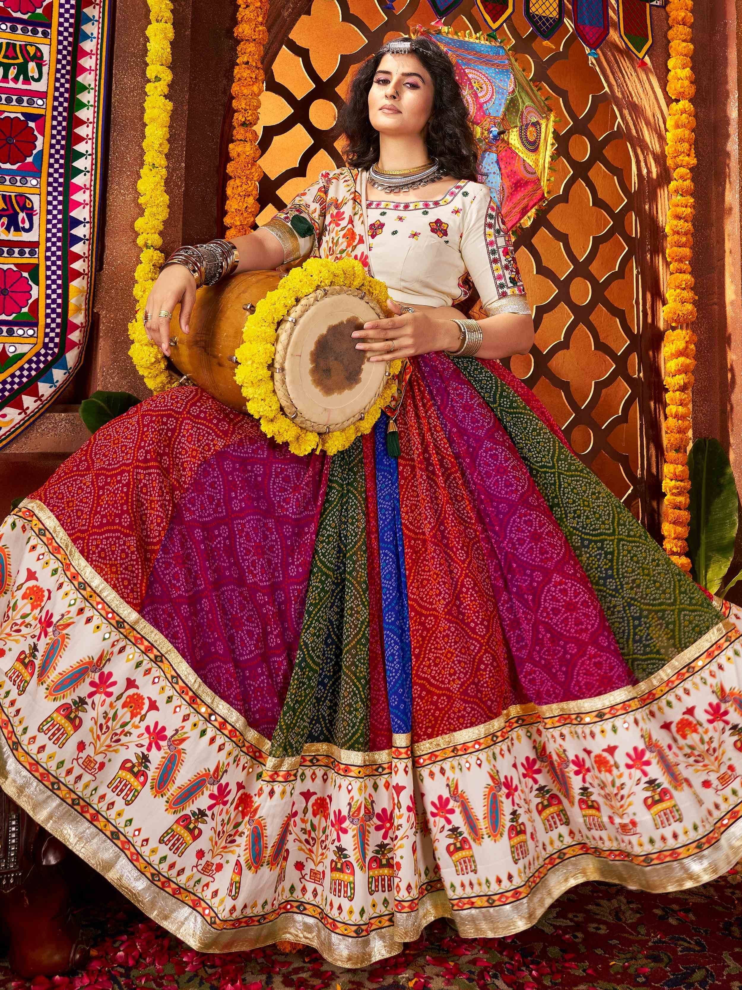 Woman in colorful Indian ethnic lehenga choli with floral embroidery, holding traditional drum, festive decor