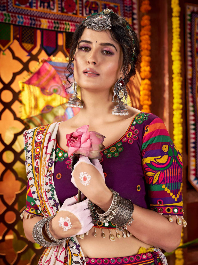 Woman in vibrant Indian ethnic wear with mirror work, holding pink rose, traditional jewelry and henna designs
