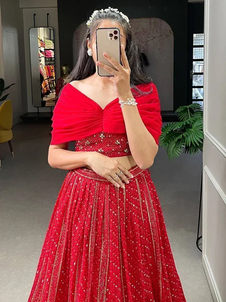 Red designer lehenga choli with embellished skirt and off-shoulder top, perfect for Indian ethnic occasions