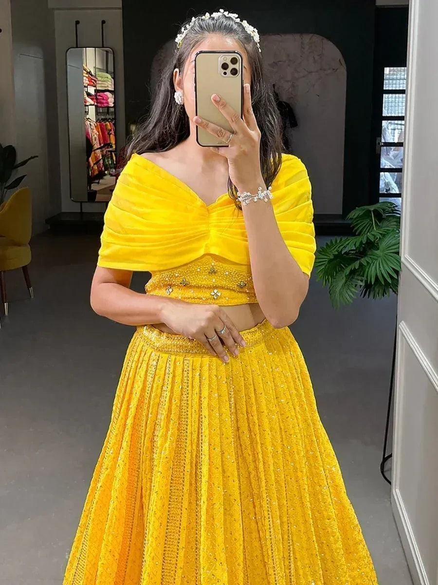 Yellow designer lehenga choli with off-shoulder blouse and embellished skirt, perfect for Indian ethnic occasions.