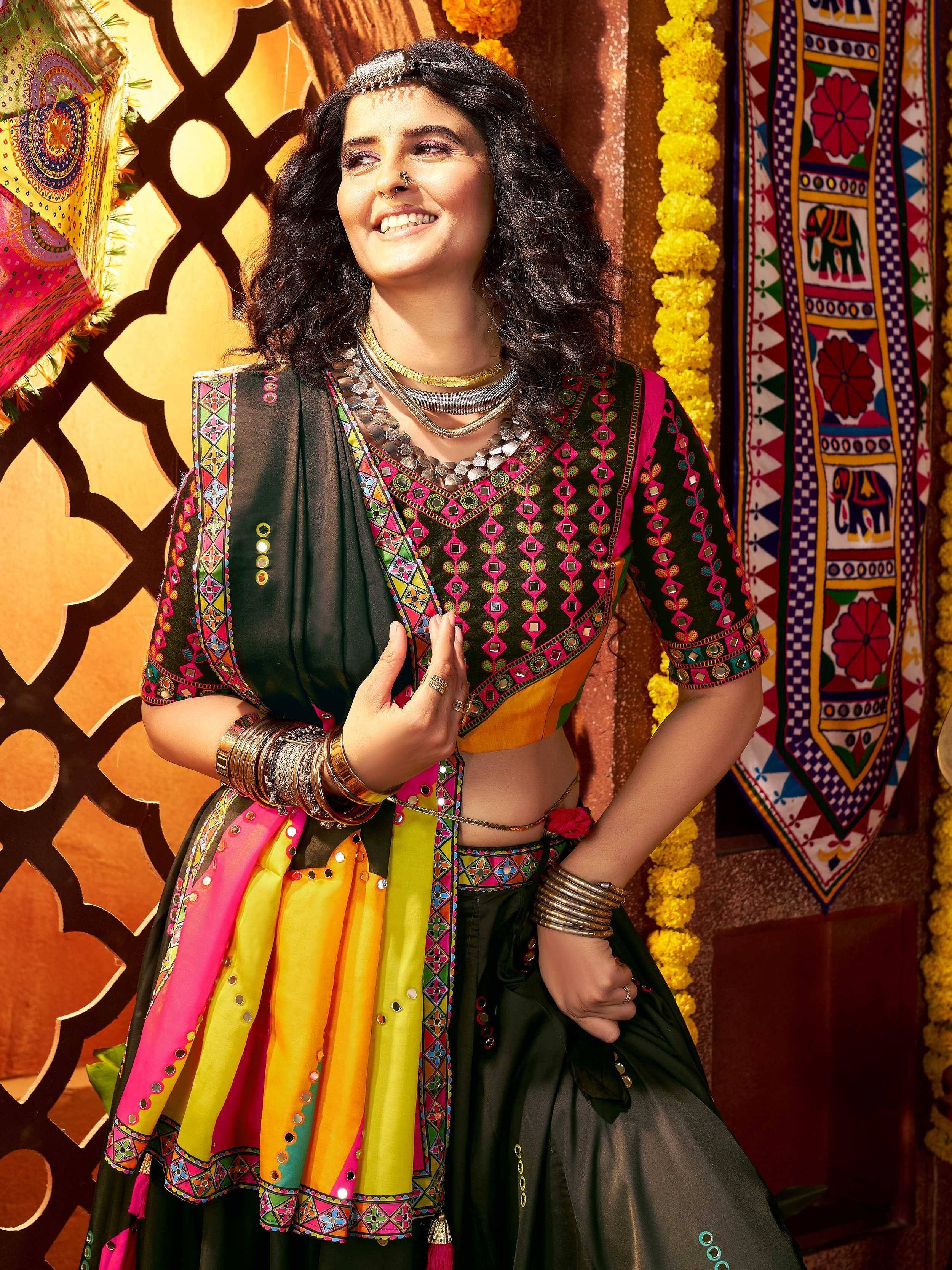 Woman in vibrant Indian ethnic wear with mirror work, colorful dupatta, and traditional jewelry