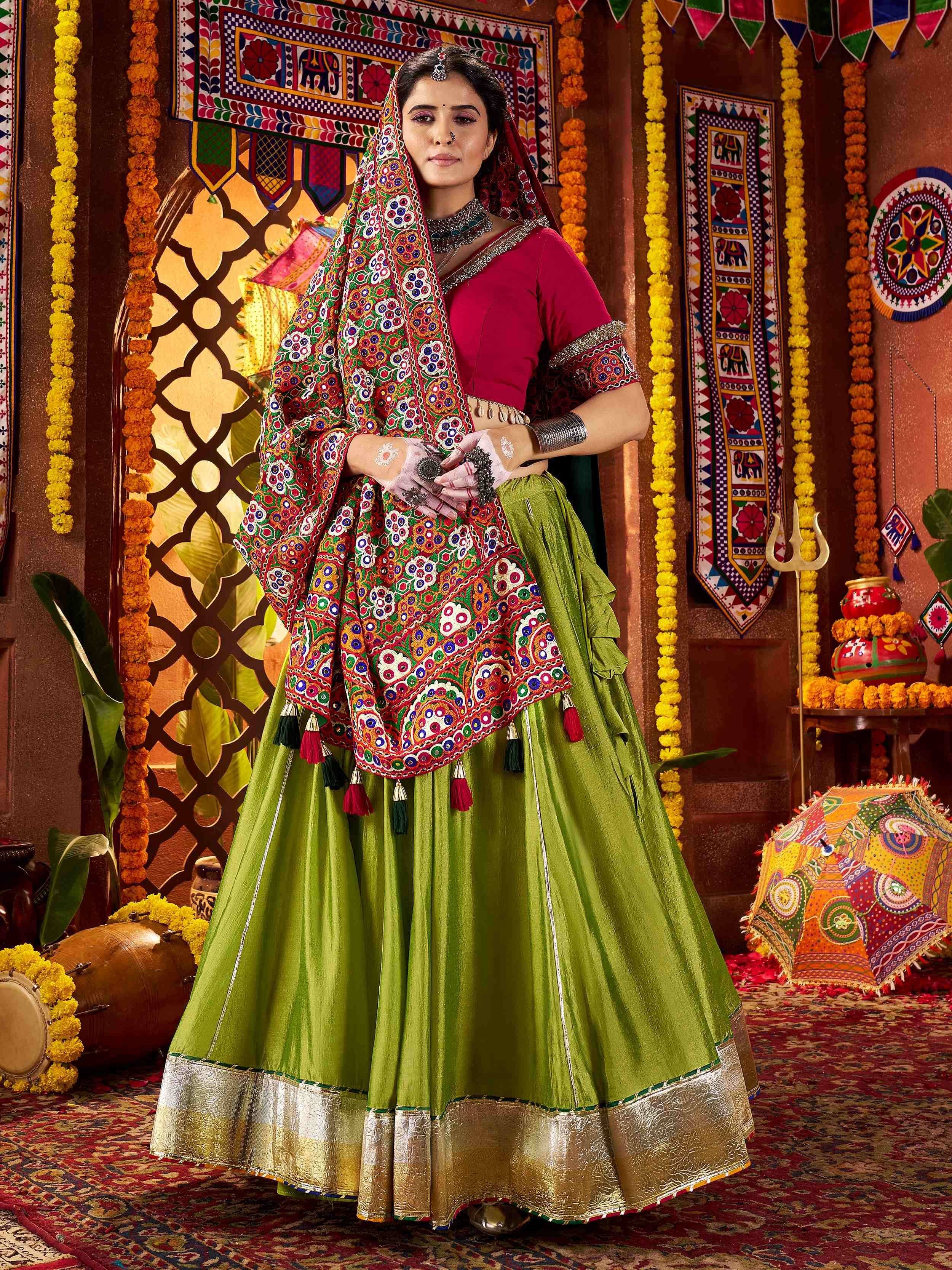 Woman in vibrant green lehenga choli with colorful mirror work dupatta, traditional Indian ethnic wear