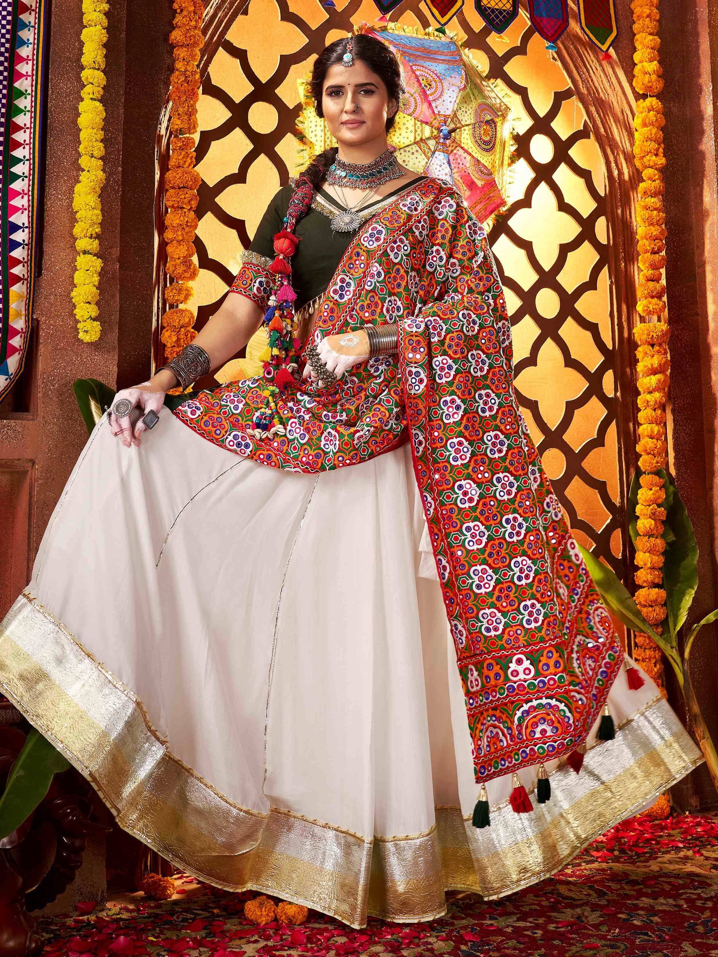 Woman in colorful embroidered Indian ethnic wear with mirror work, floral garlands, and traditional jewelry