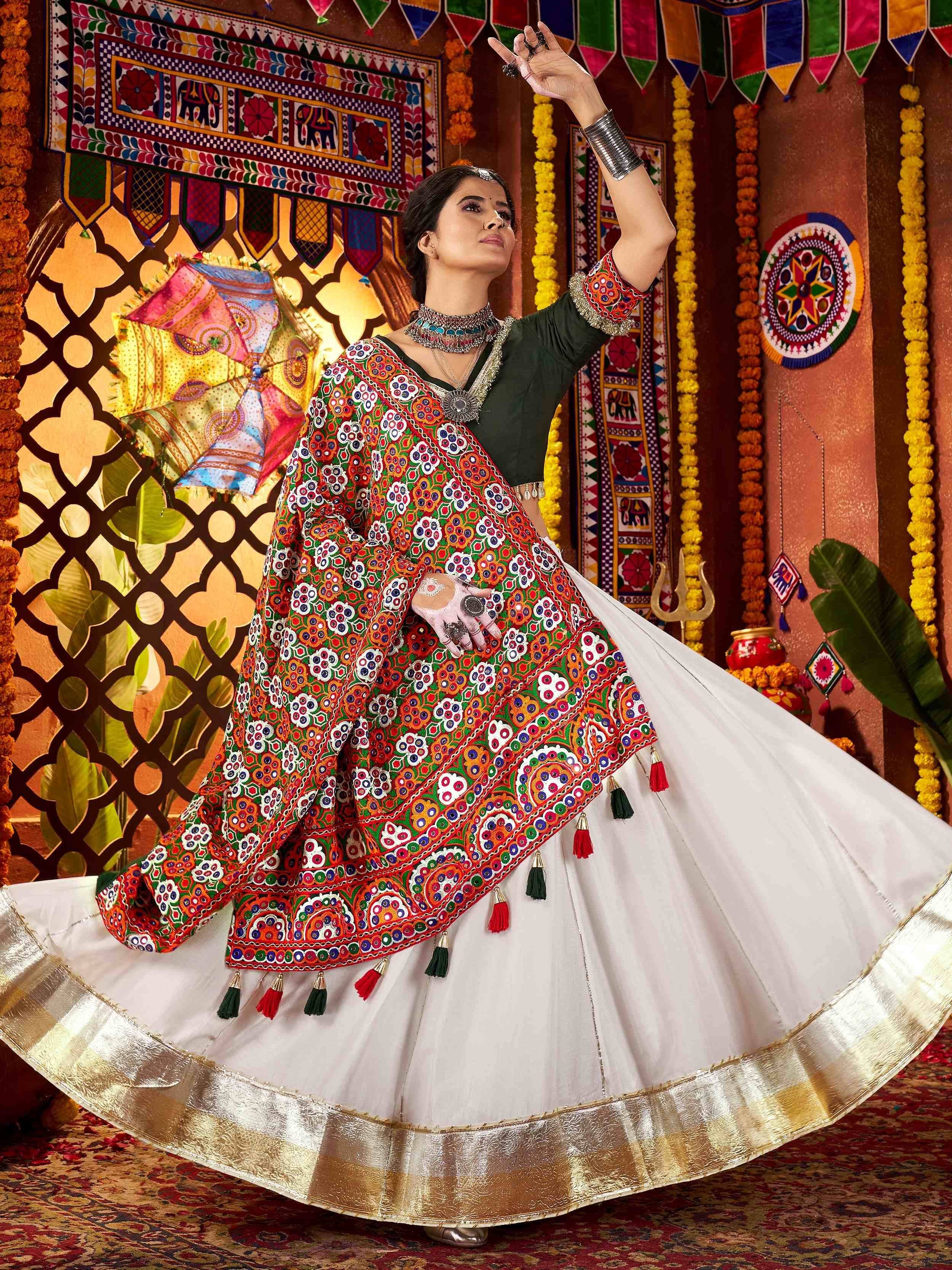 Woman in vibrant embroidered Indian ethnic wear, dancing with colorful backdrop and traditional decor