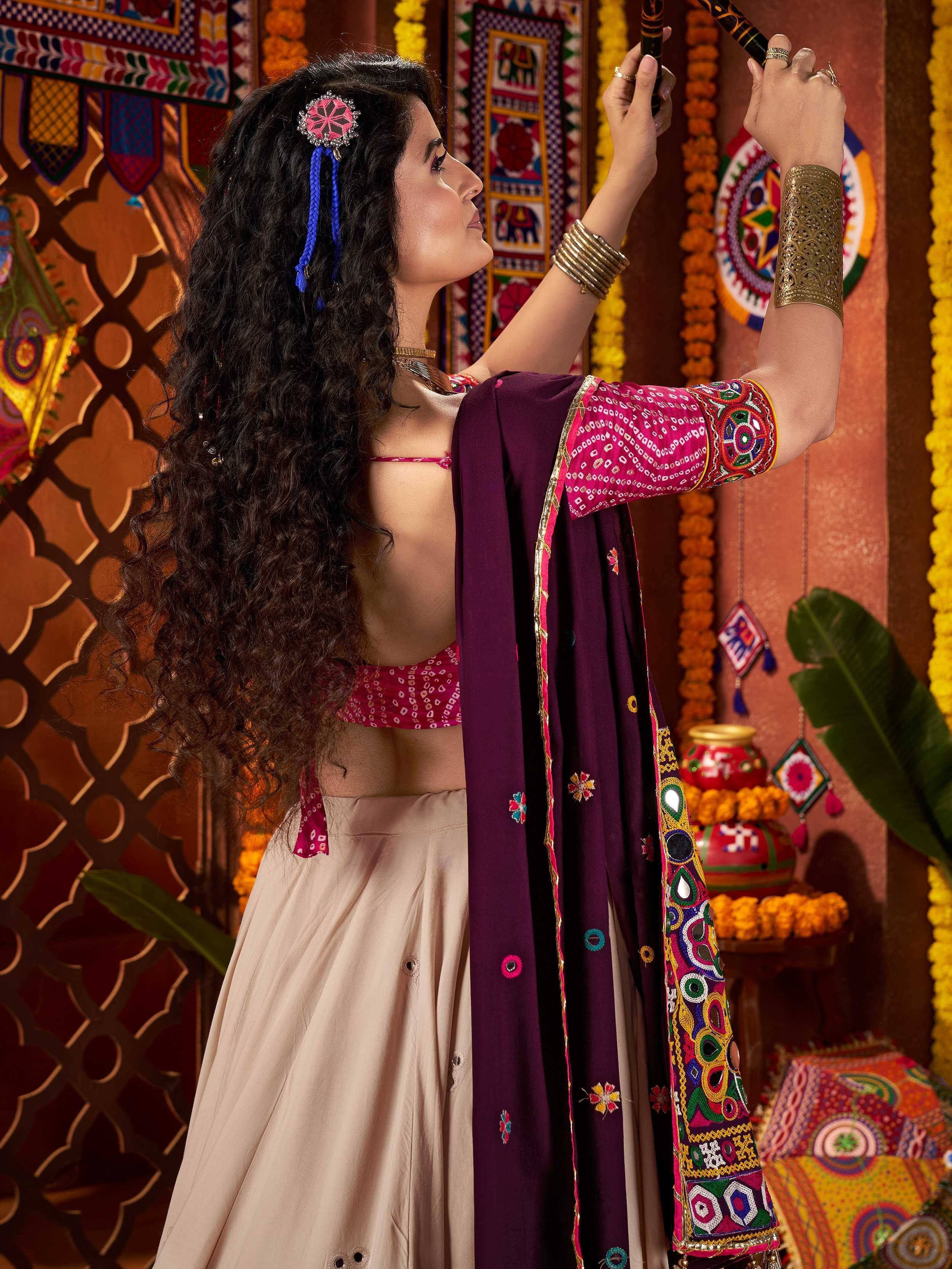 Woman in ethnic lehenga choli with vibrant embroidery and traditional accessories