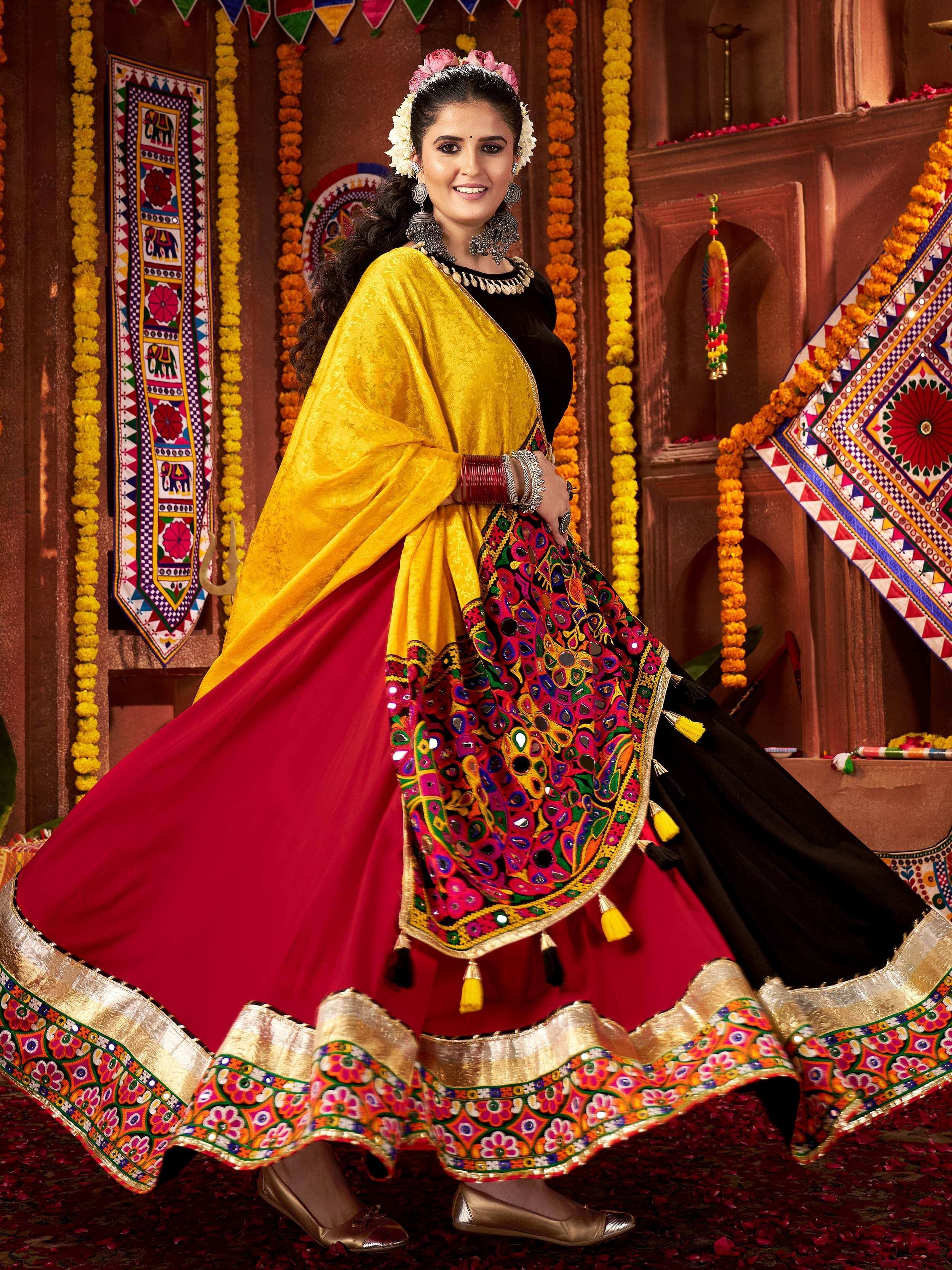 Vibrant red and yellow ethnic lehenga with mirror work and floral embroidery, perfect for festive occasions.