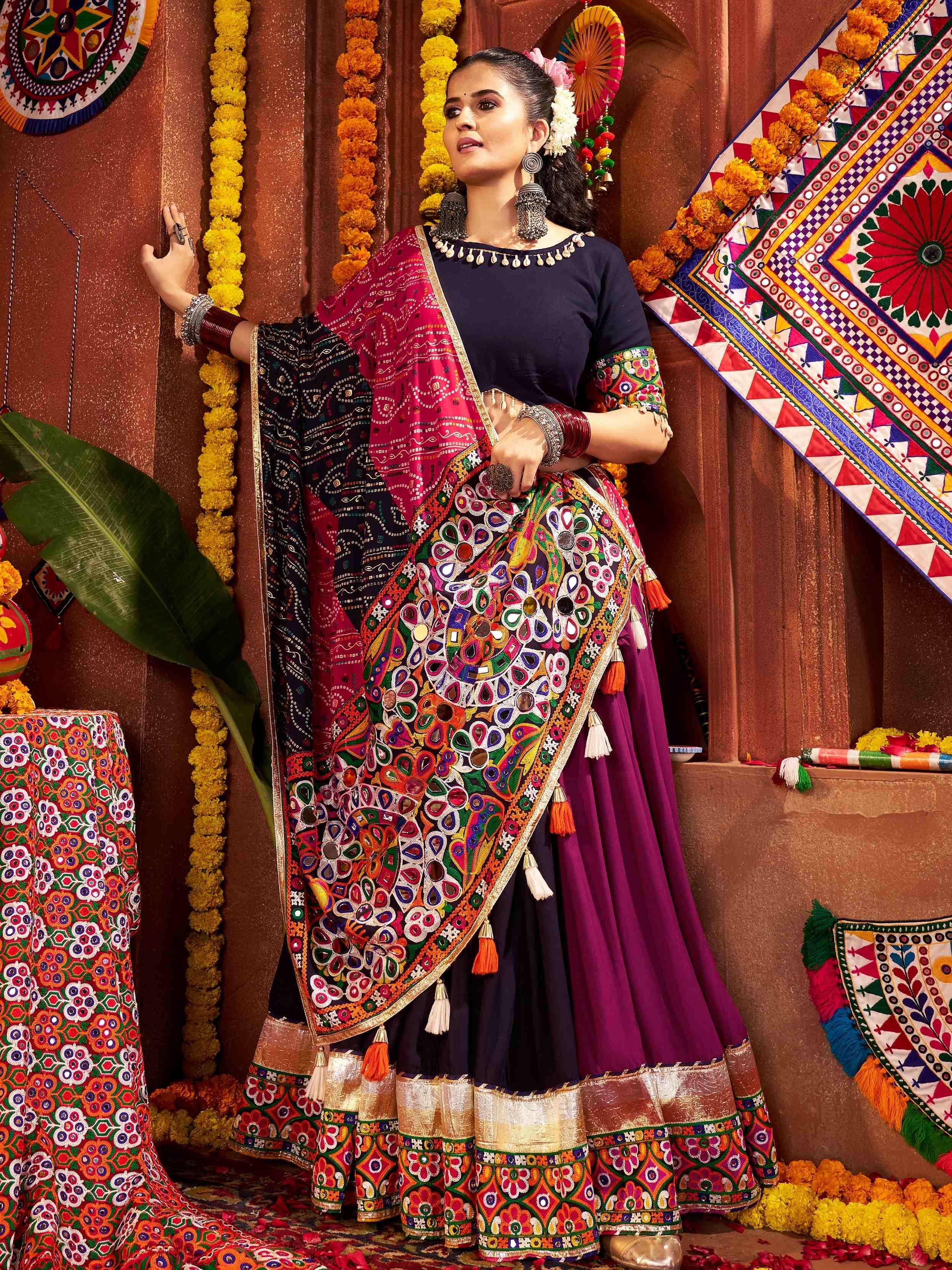 Woman in vibrant Indian ethnic wear with mirror work, floral garlands, and traditional jewelry