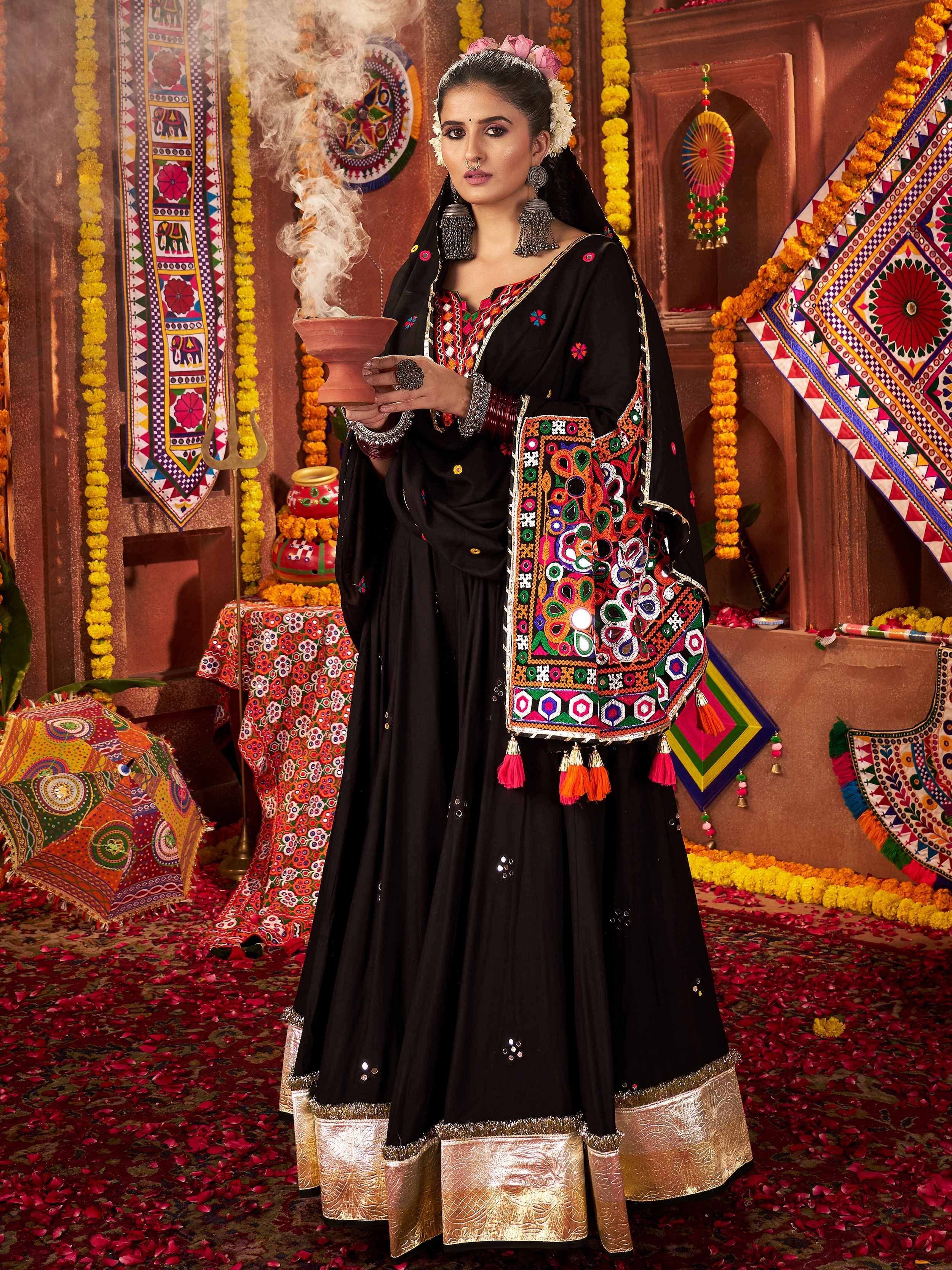 Black embroidered ethnic gown with colorful mirror work and gold border, perfect for festive occasions