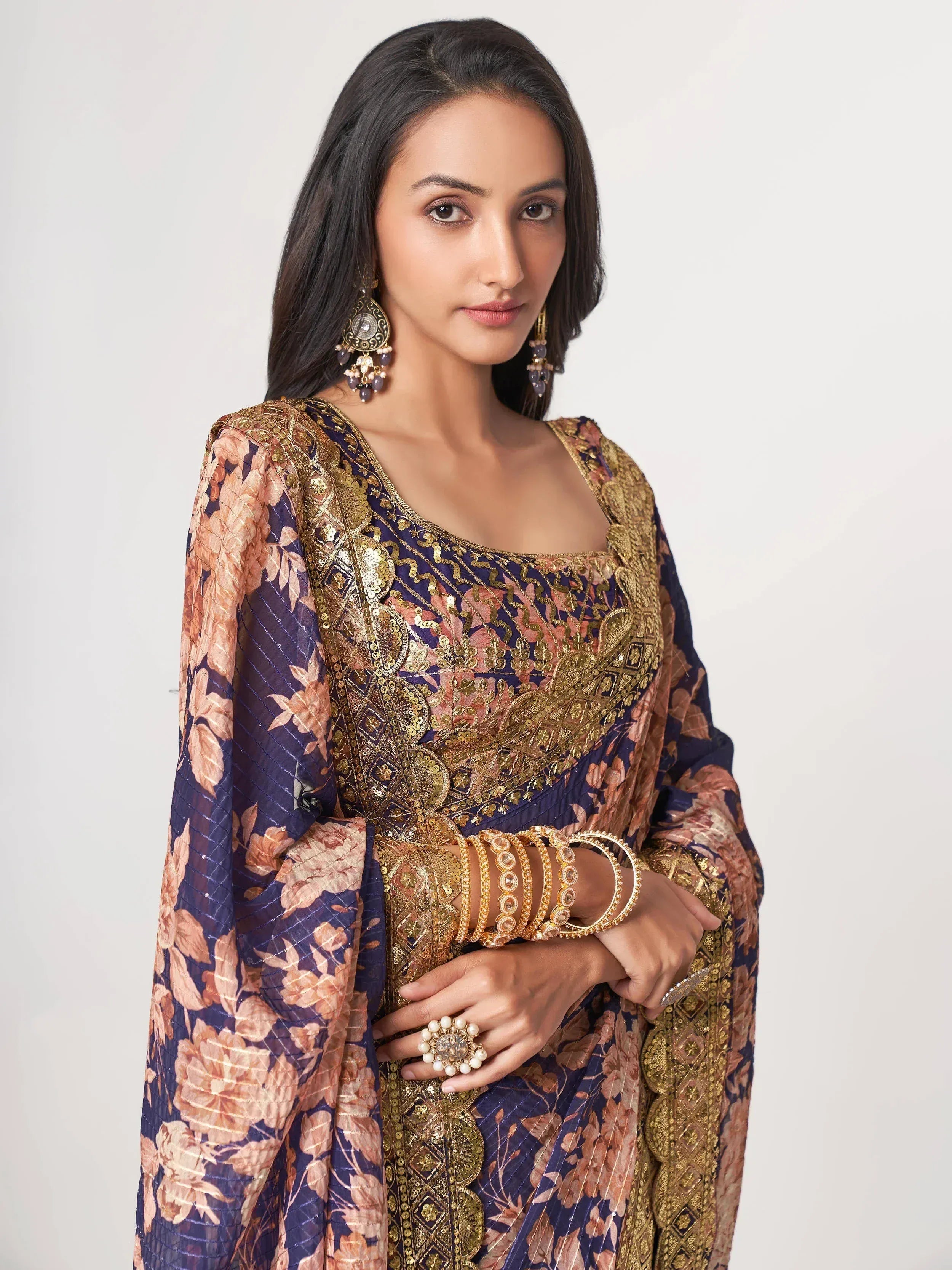 Elegant Indian ethnic wear with floral print and gold embroidery, paired with traditional jewelry
