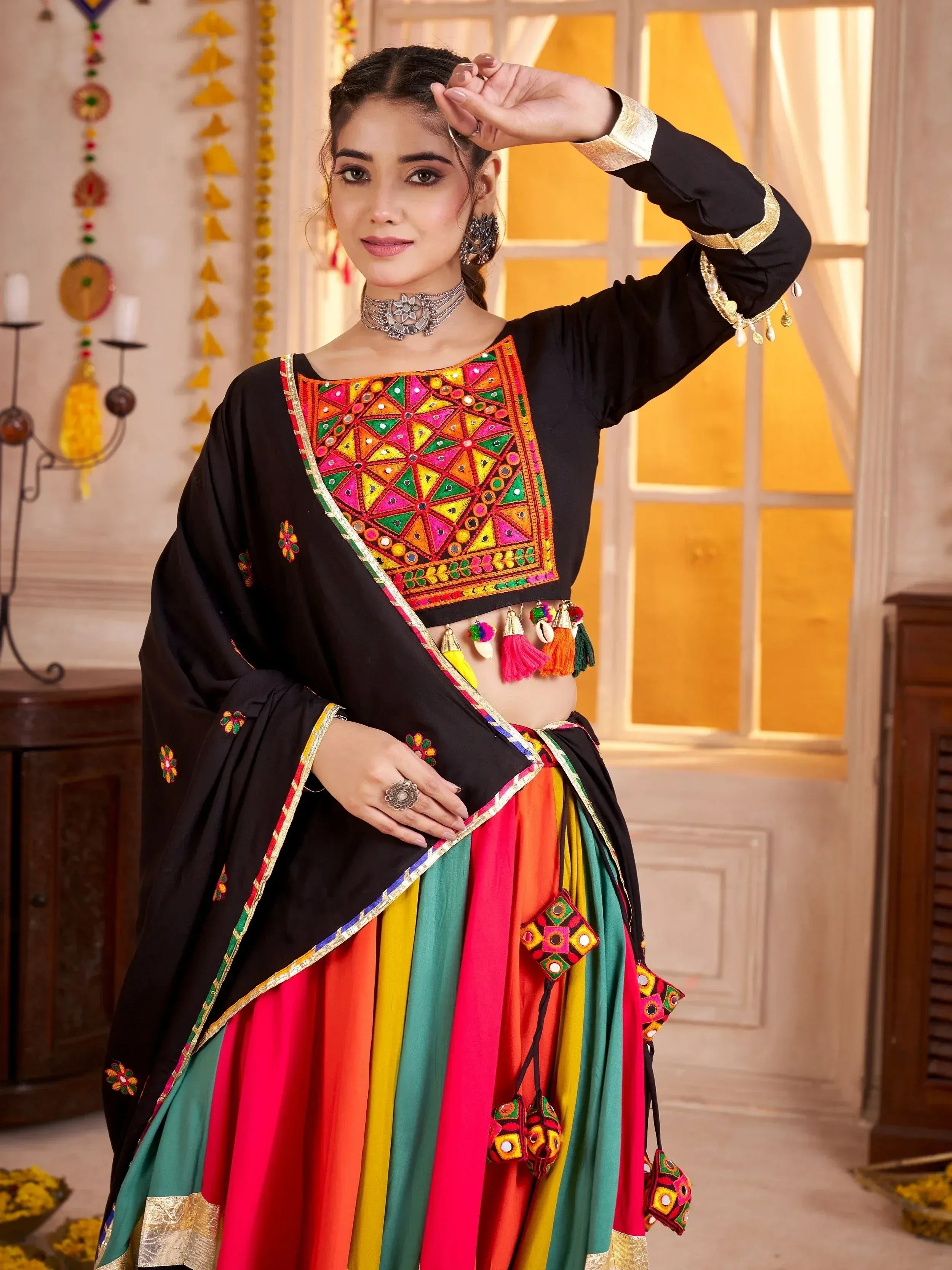 Black embroidered choli with colorful mirror work, paired with rainbow pleated skirt and dupatta, Indian ethnic wear