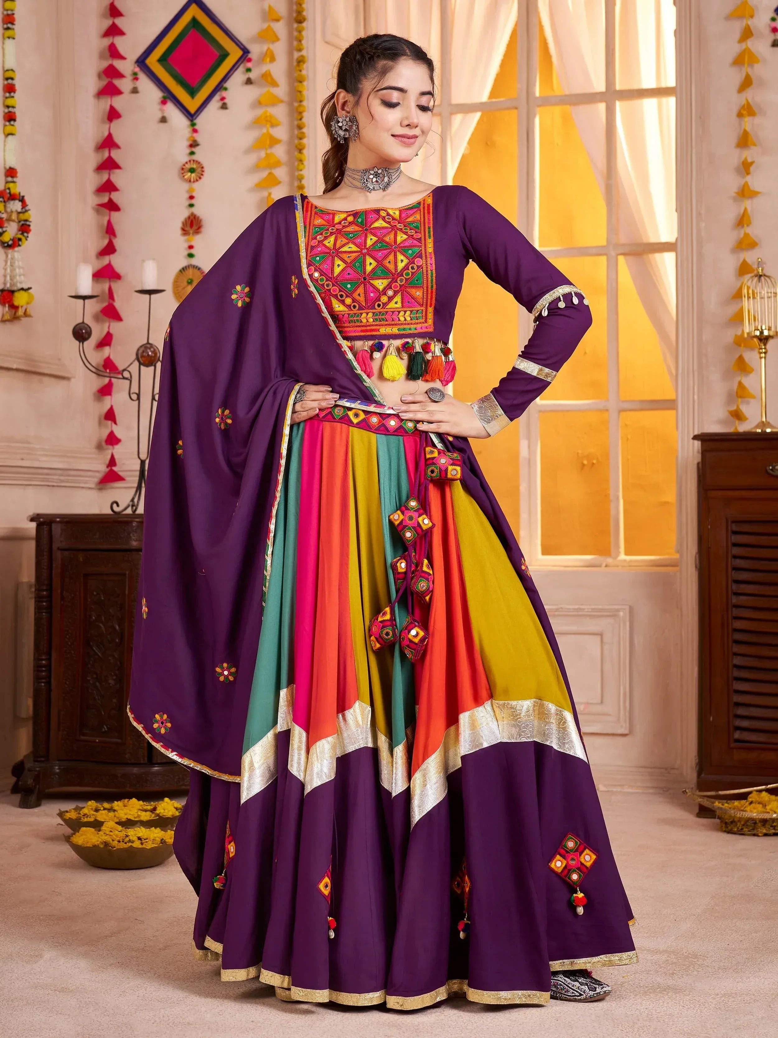 Vibrant purple Indian lehenga choli with colorful mirror work, tassels, and embroidered dupatta for festive occasions