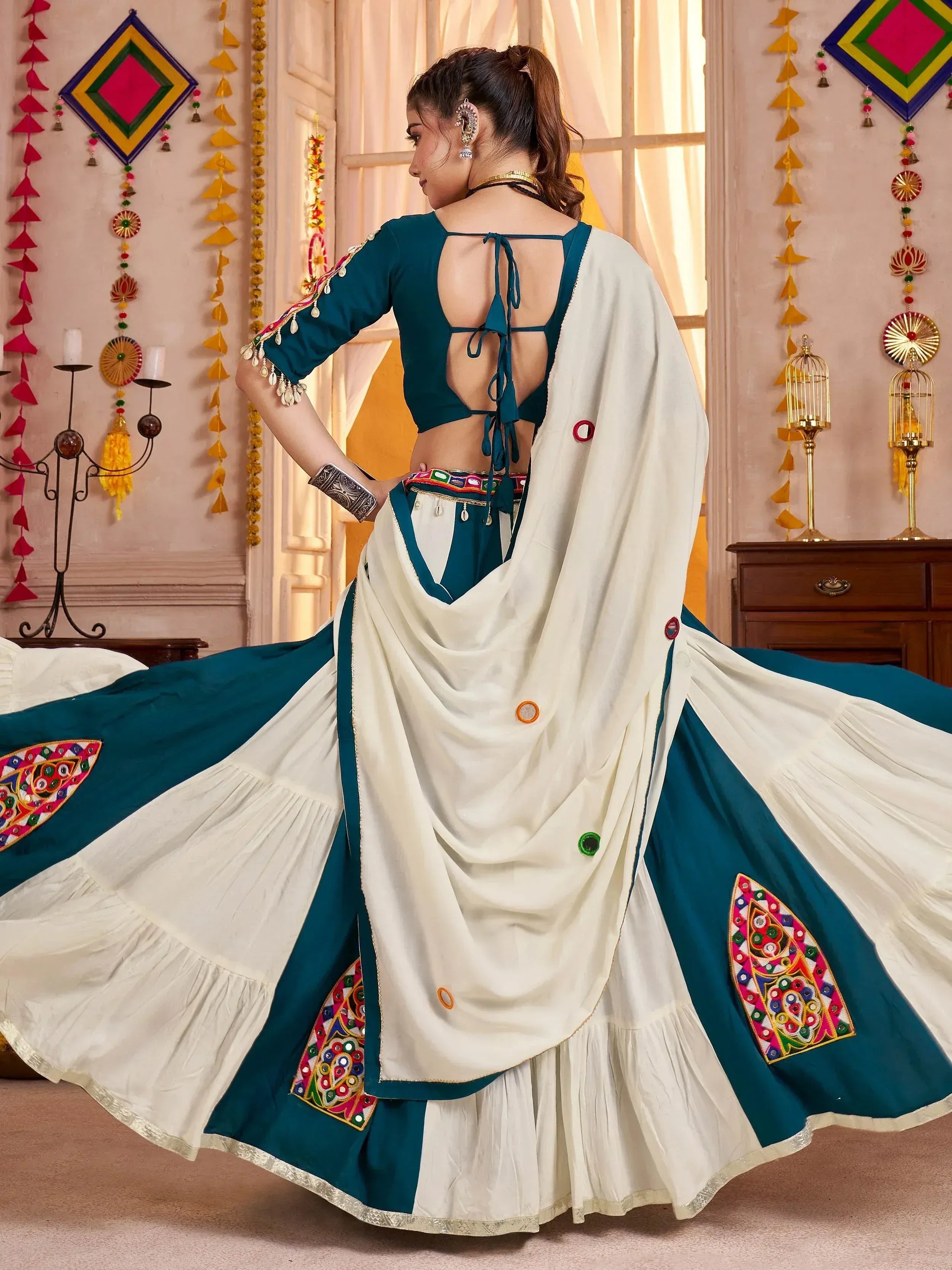 Teal and white ethnic lehenga choli with mirror work, backless blouse, and embroidered dupatta for festive wear