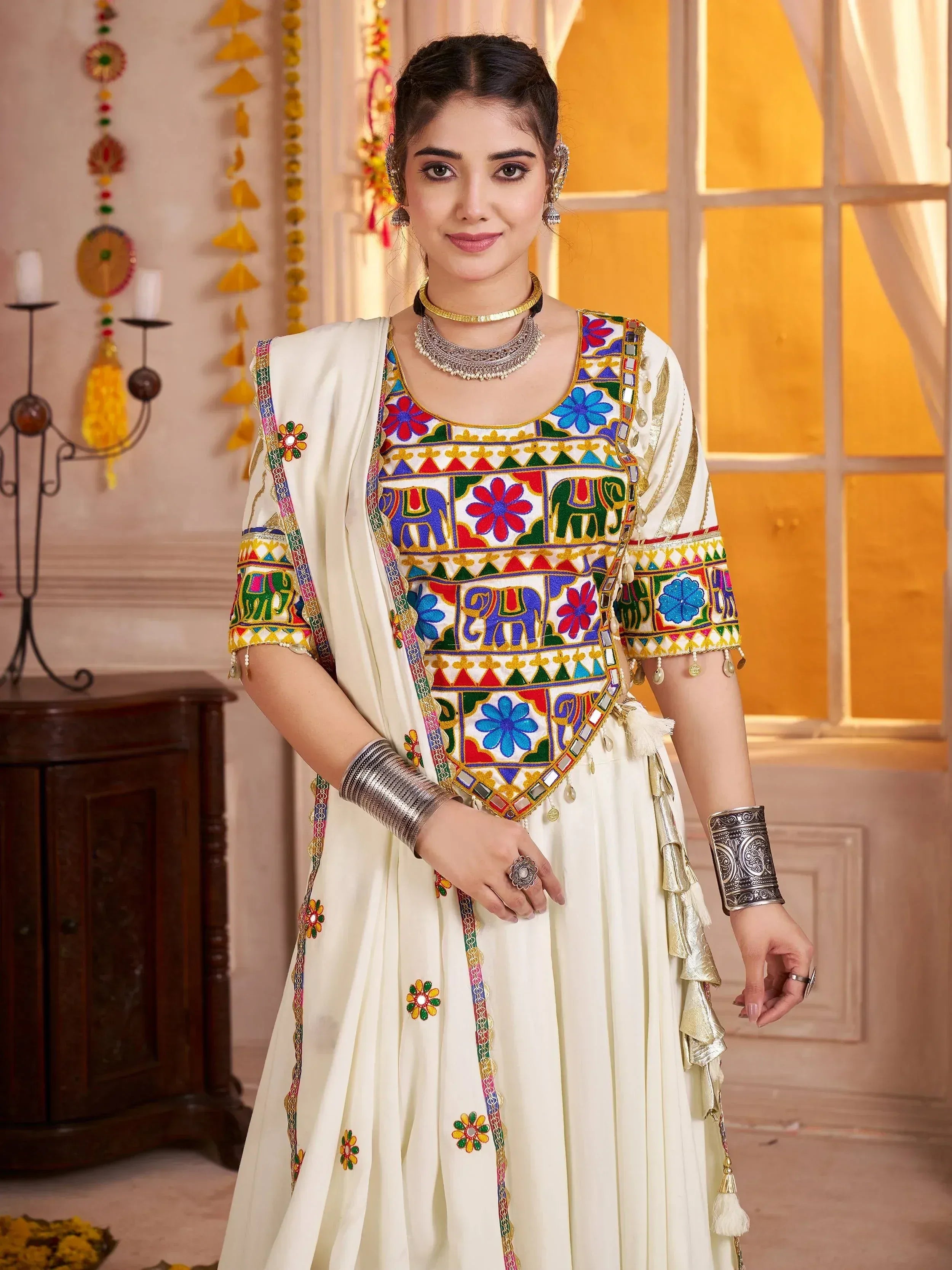 Woman in cream embroidered ethnic anarkali with colorful floral and elephant motifs, traditional Indian attire