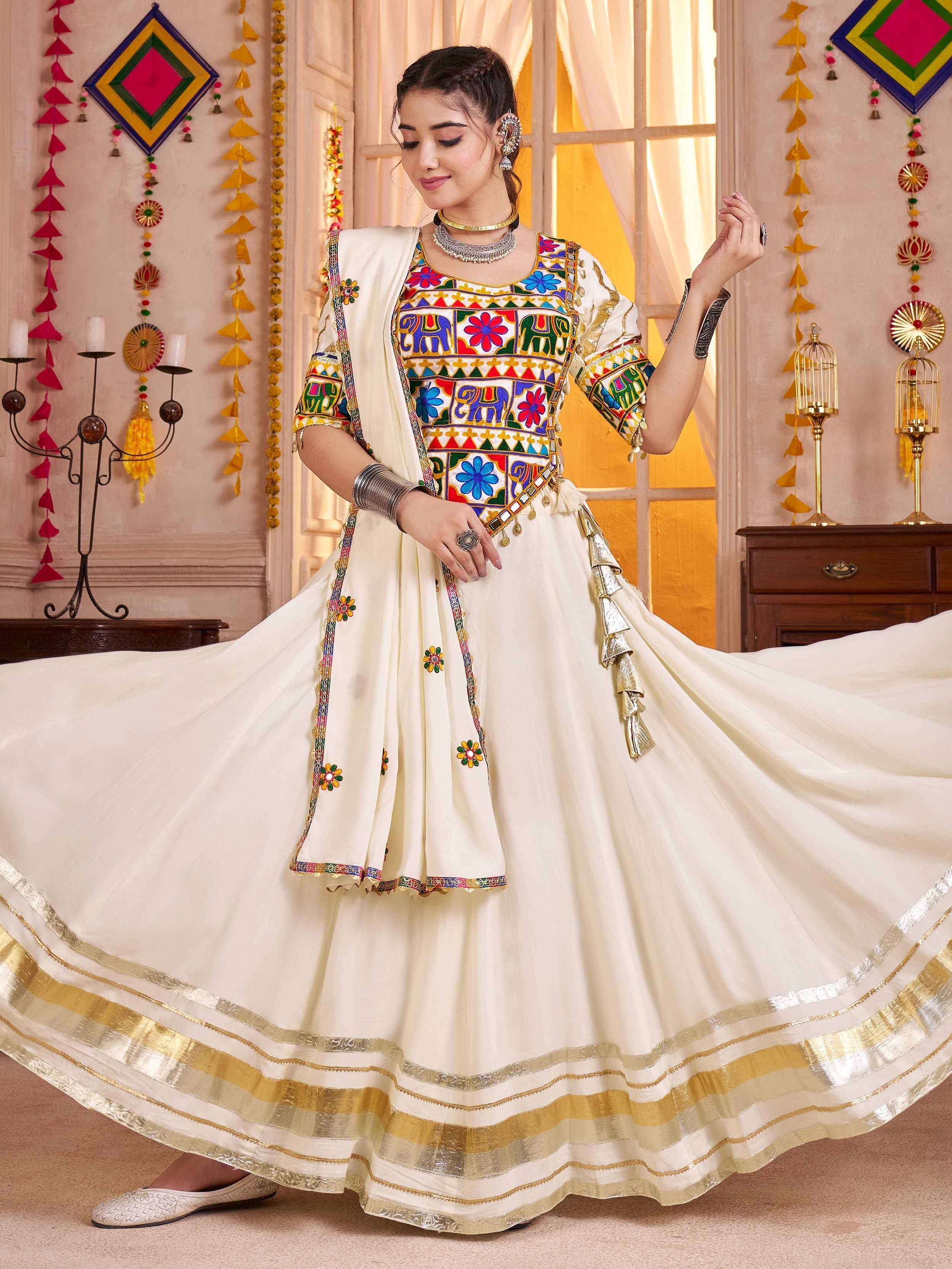 Woman in white embroidered lehenga choli with elephant and floral motifs, gold border, festive Indian ethnic wear