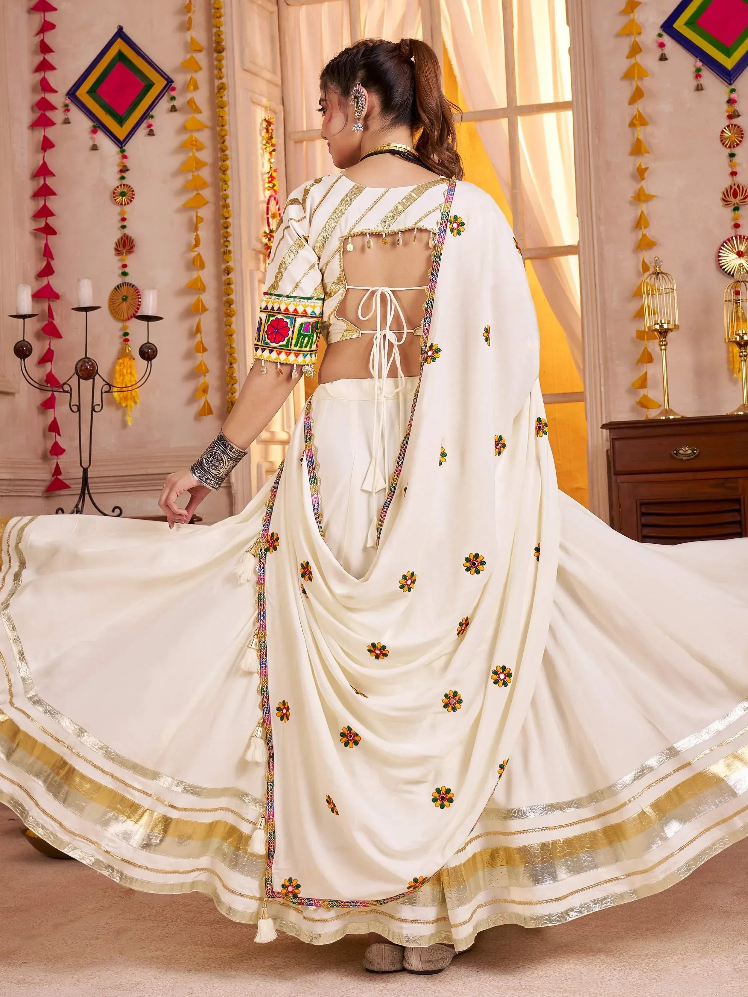 White embroidered lehenga choli with gold trim and floral motifs, back view with tie-up detail