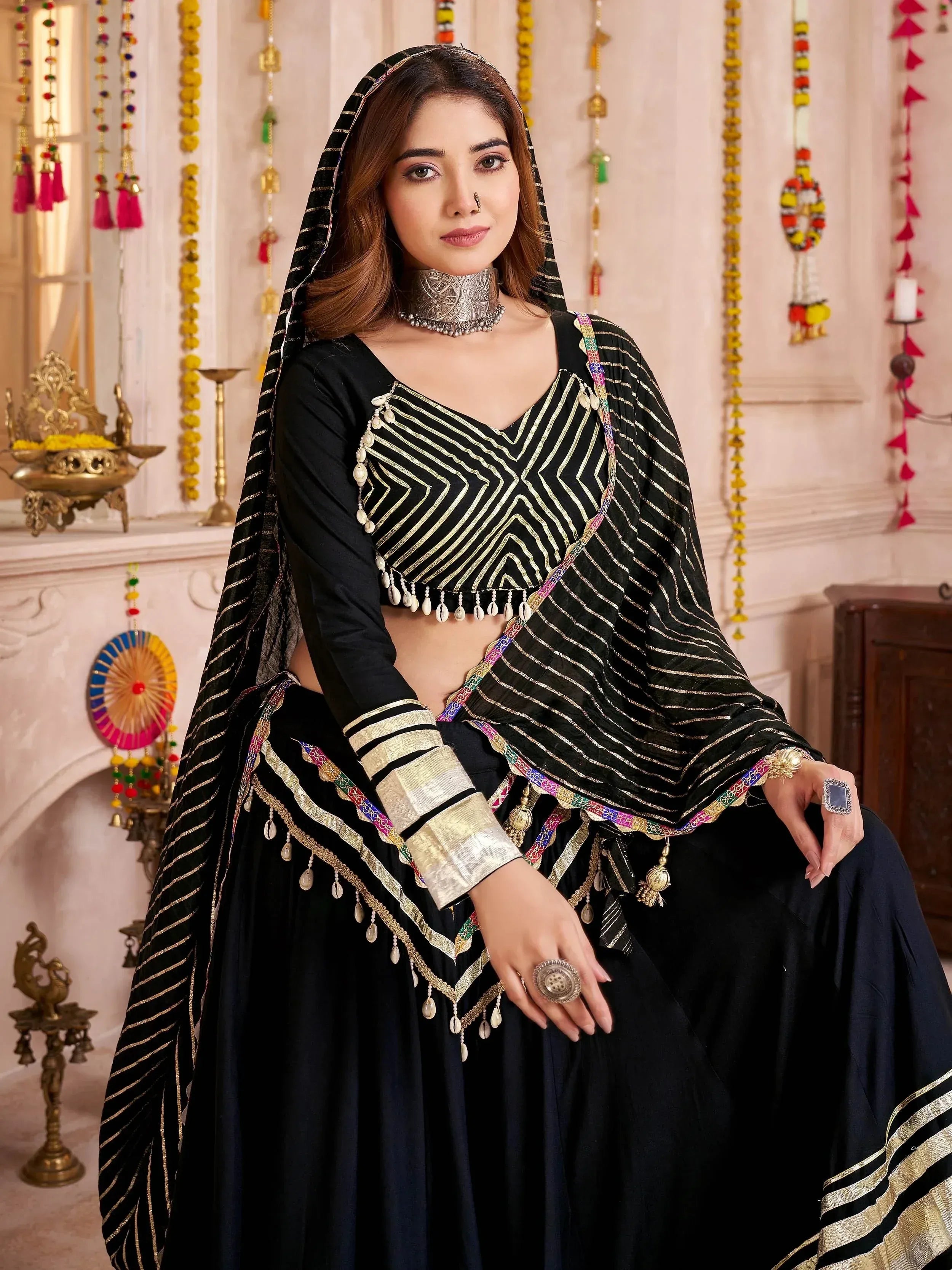 Black and gold ethnic lehenga choli with mirror work, perfect for Indian weddings and festivals.