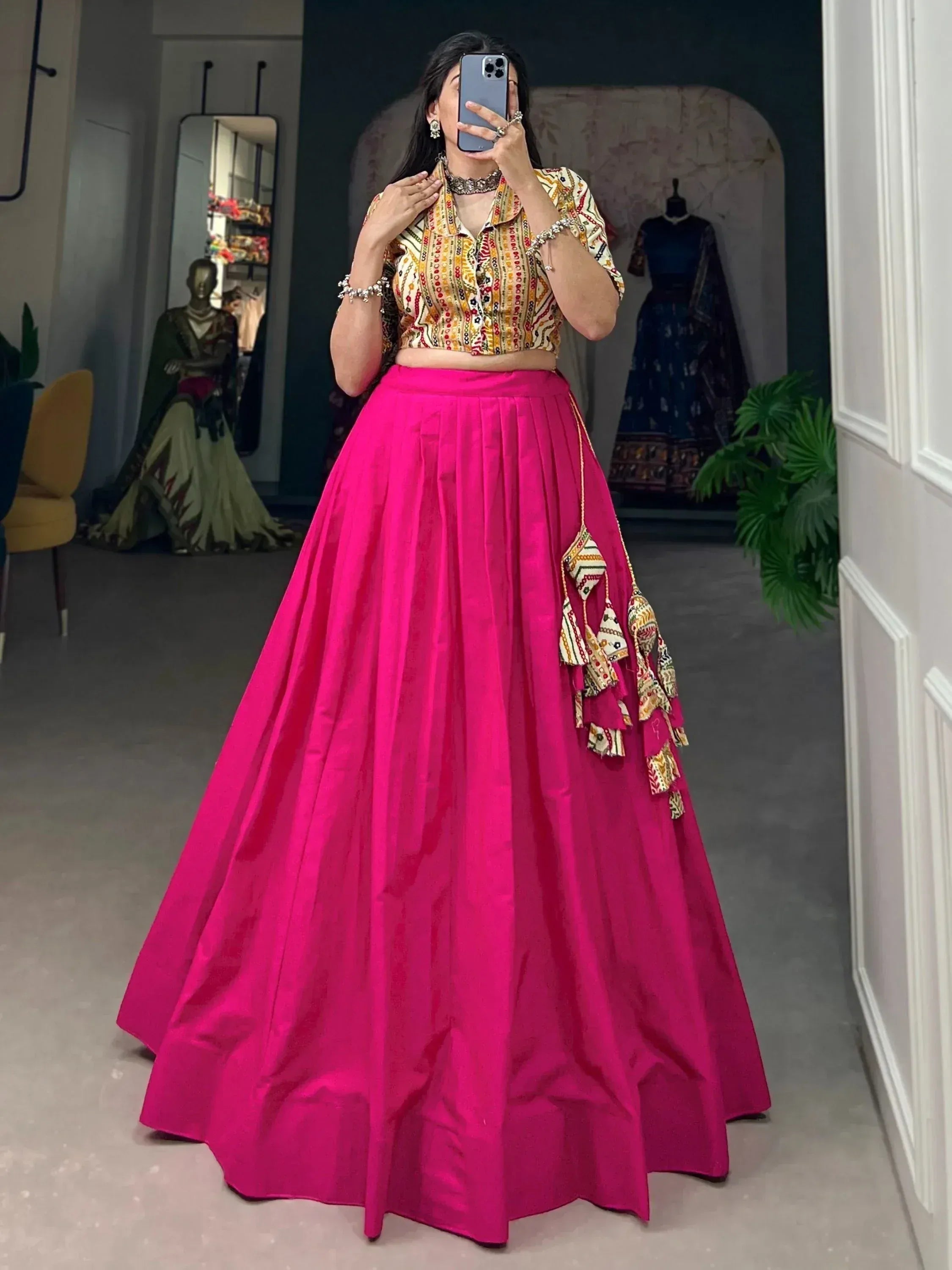 Woman in vibrant pink lehenga with printed crop top, ethnic Indian wear for festive occasions