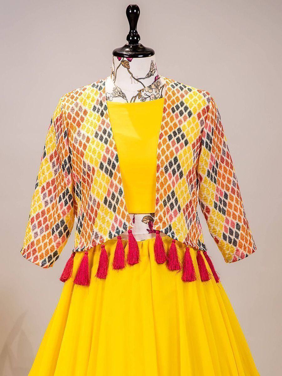 Vibrant yellow lehenga choli with printed jacket and pink tassels, ethnic Indian wear