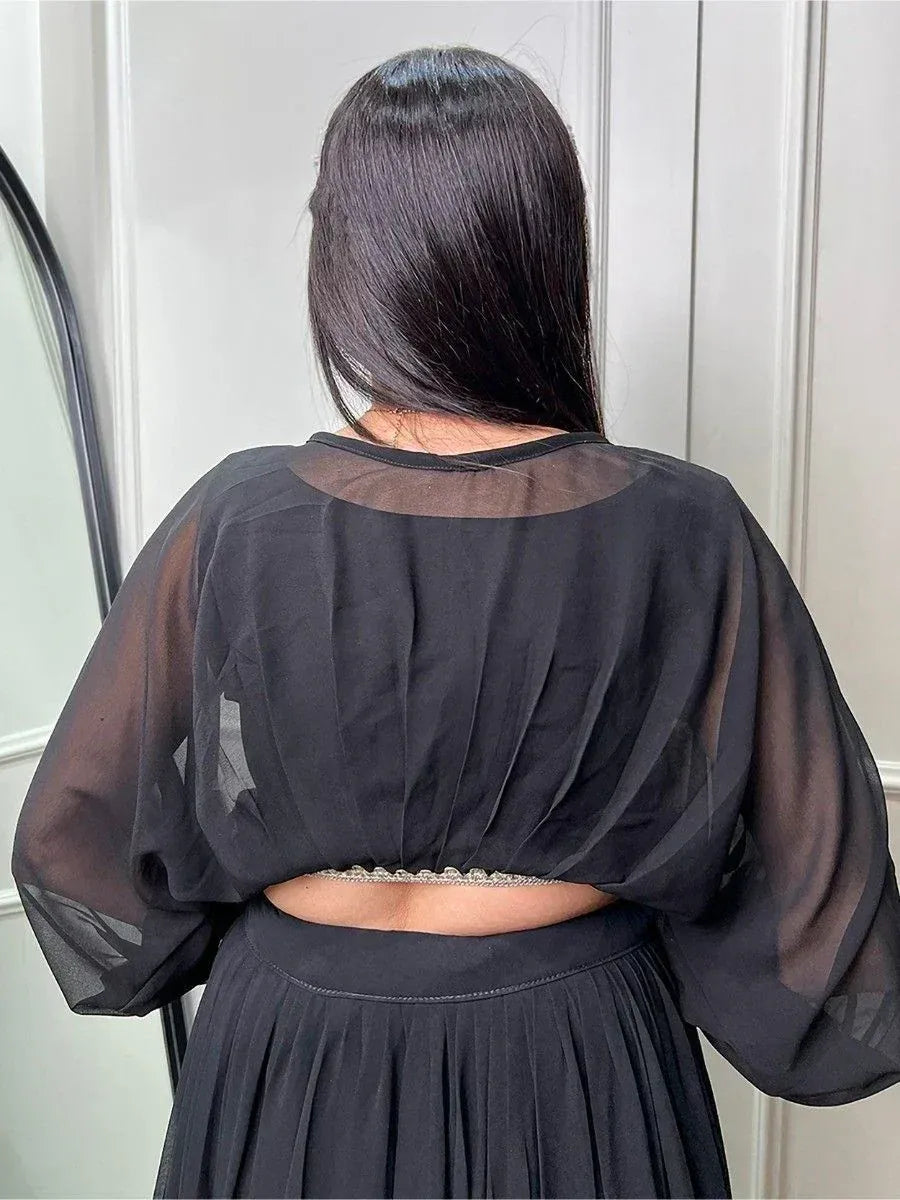 Black sheer backless top with pleated detail, paired with matching skirt for ethnic wear