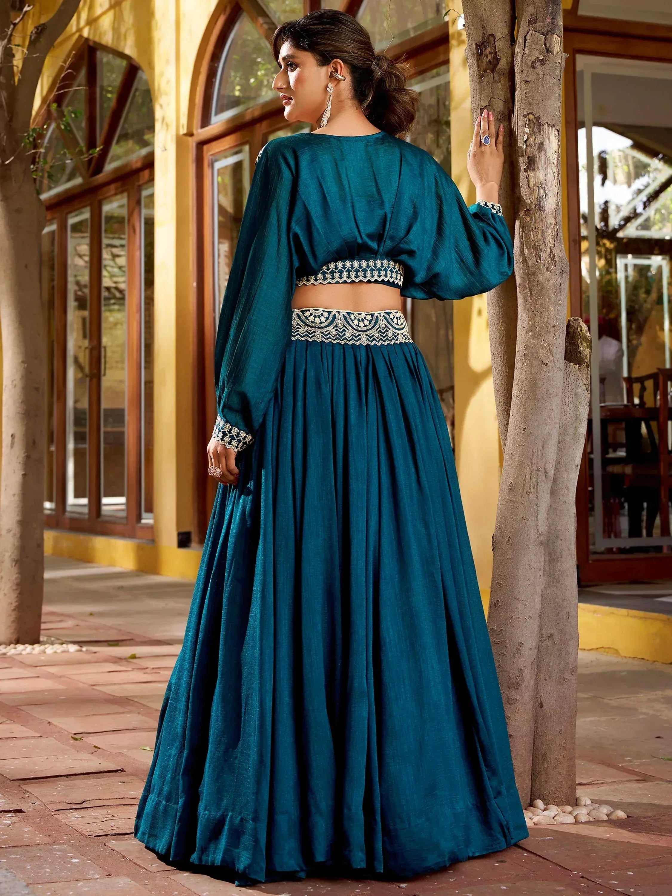 Teal designer lehenga choli with embroidered waistband and sleeves, perfect for Indian ethnic occasions.