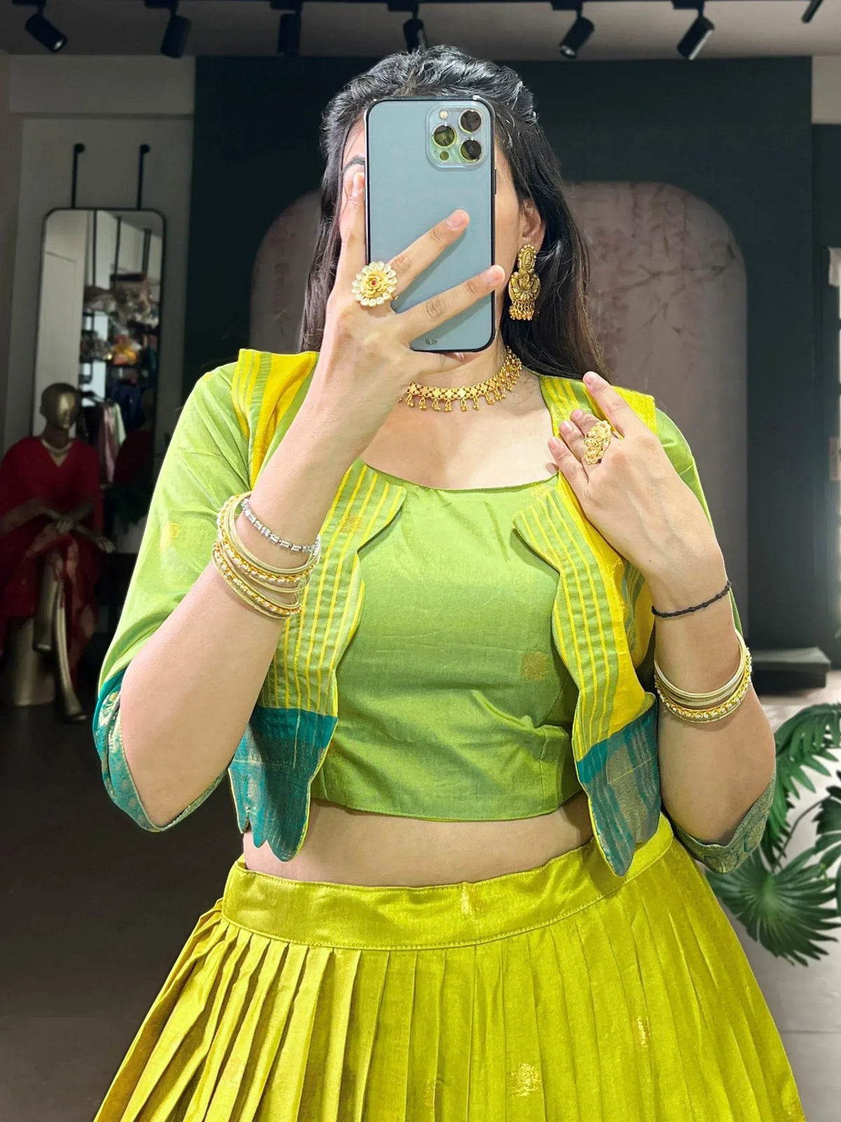 Vibrant green and yellow ethnic lehenga choli with gold jewelry, perfect for festive occasions.