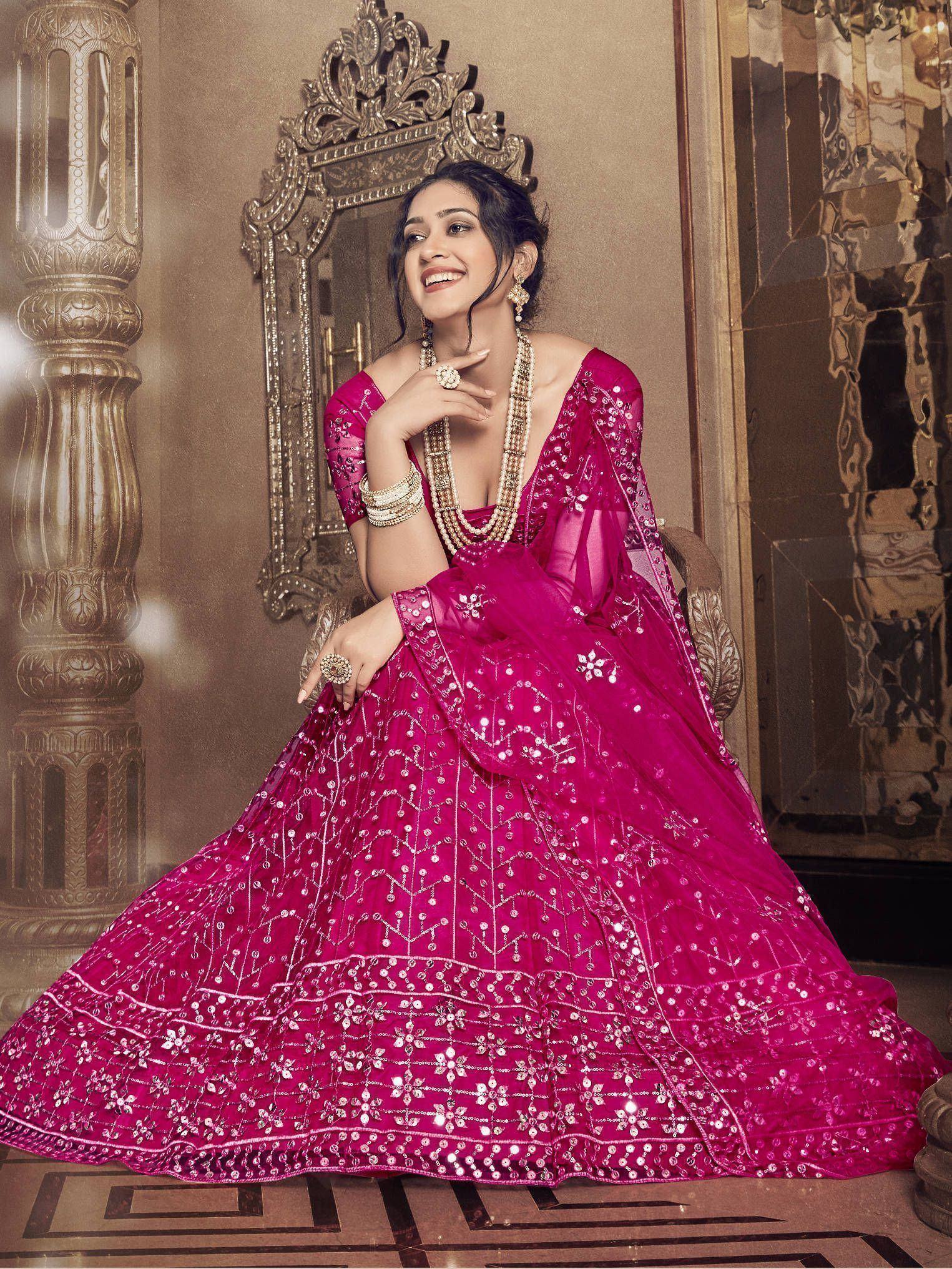 Fuchsia designer lehenga choli with intricate silver embroidery and sequins, perfect for Indian weddings and festive occasions.