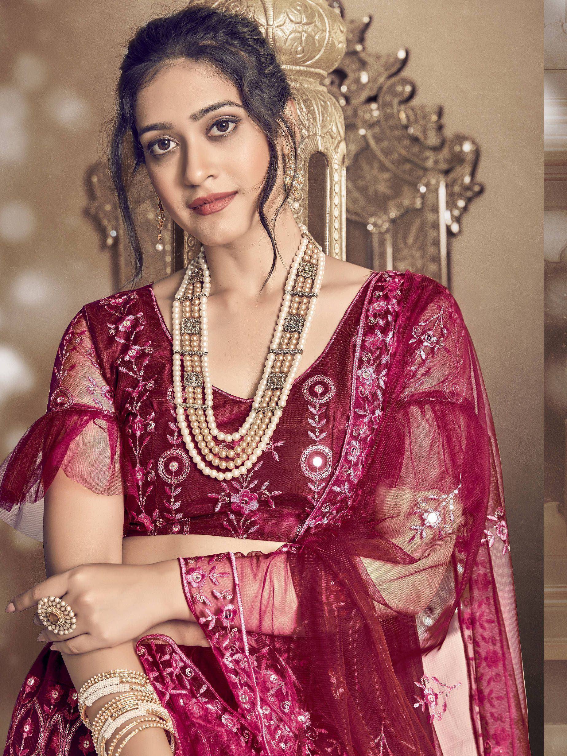 Elegant maroon embroidered lehenga choli with pearl jewelry, perfect for Indian ethnic occasions.