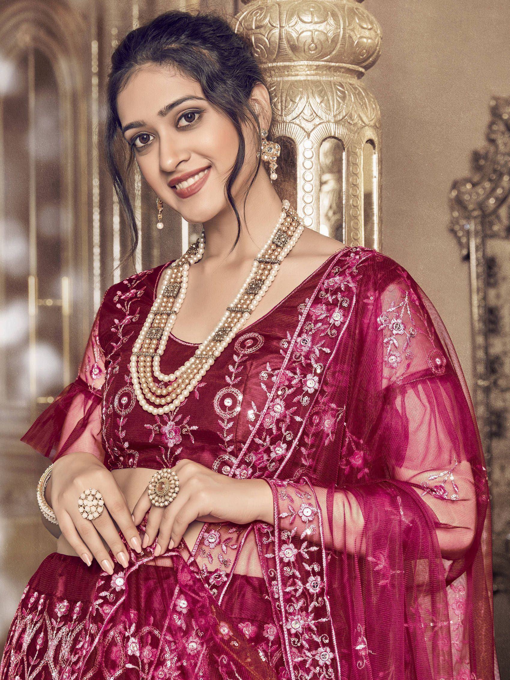 Woman in maroon embroidered lehenga choli with pearl jewelry, Indian ethnic wear