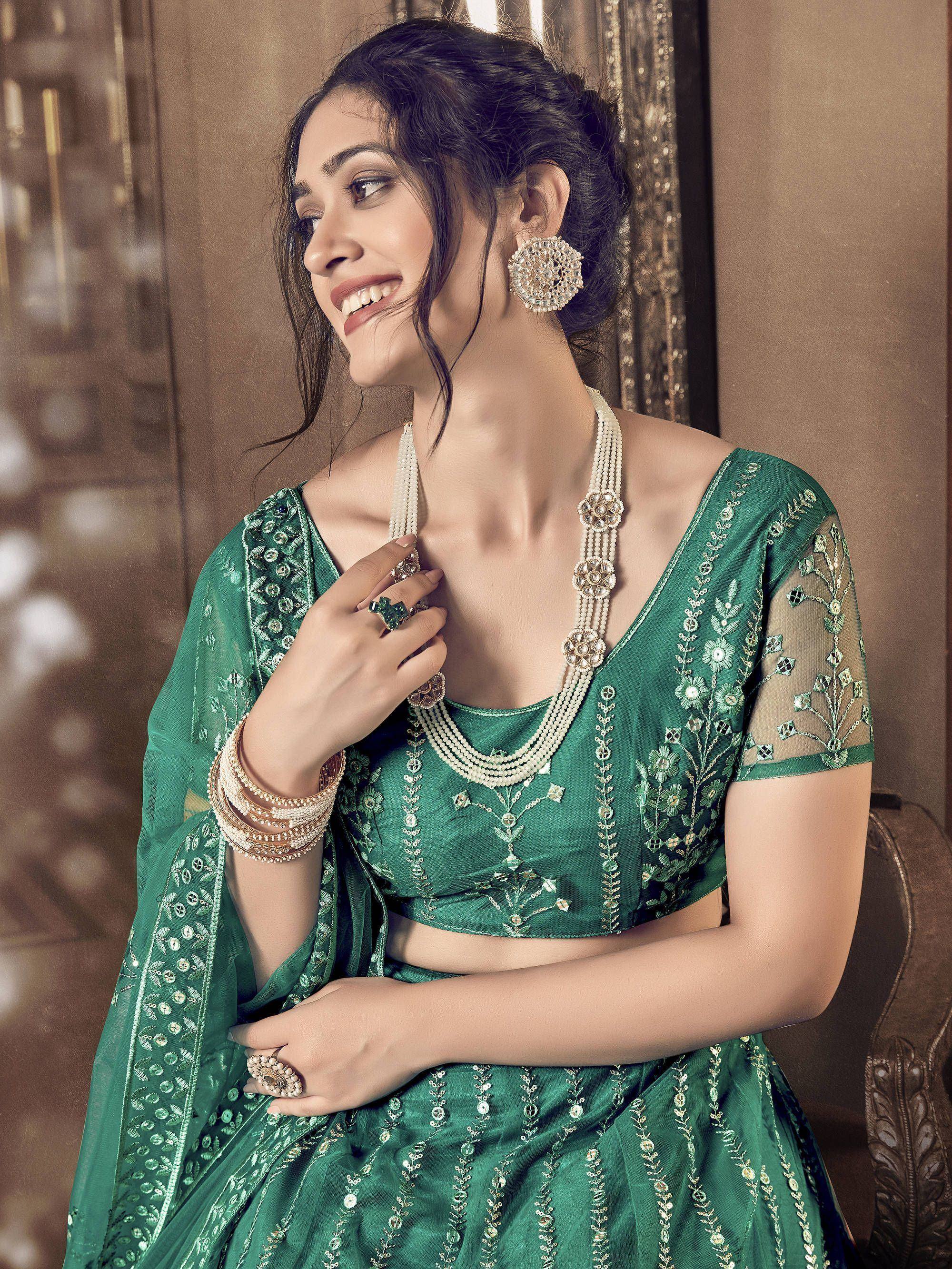 Emerald green embroidered lehenga choli with pearl jewelry, perfect for Indian ethnic wear occasions.